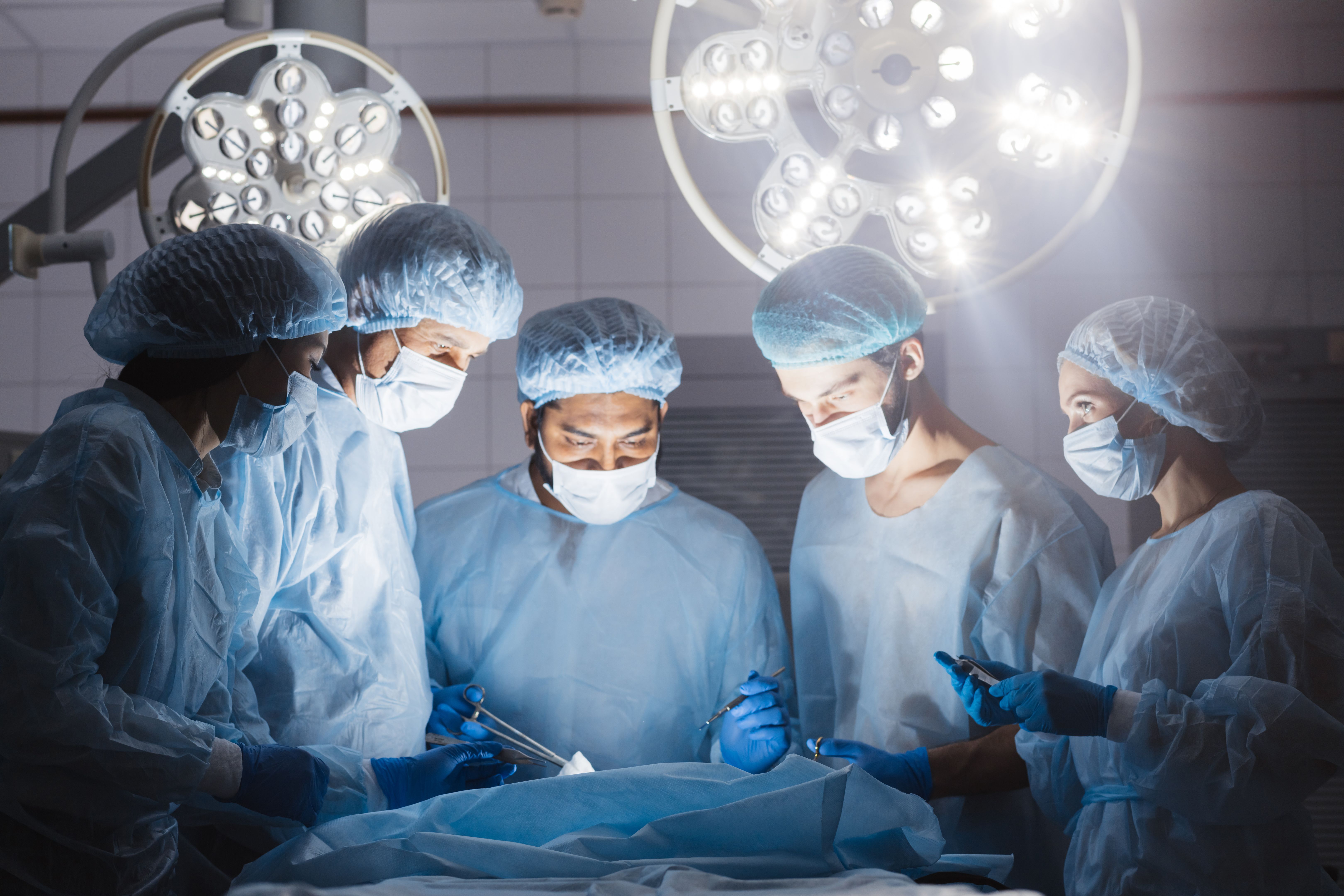 Doctors team in surgery in a dark background