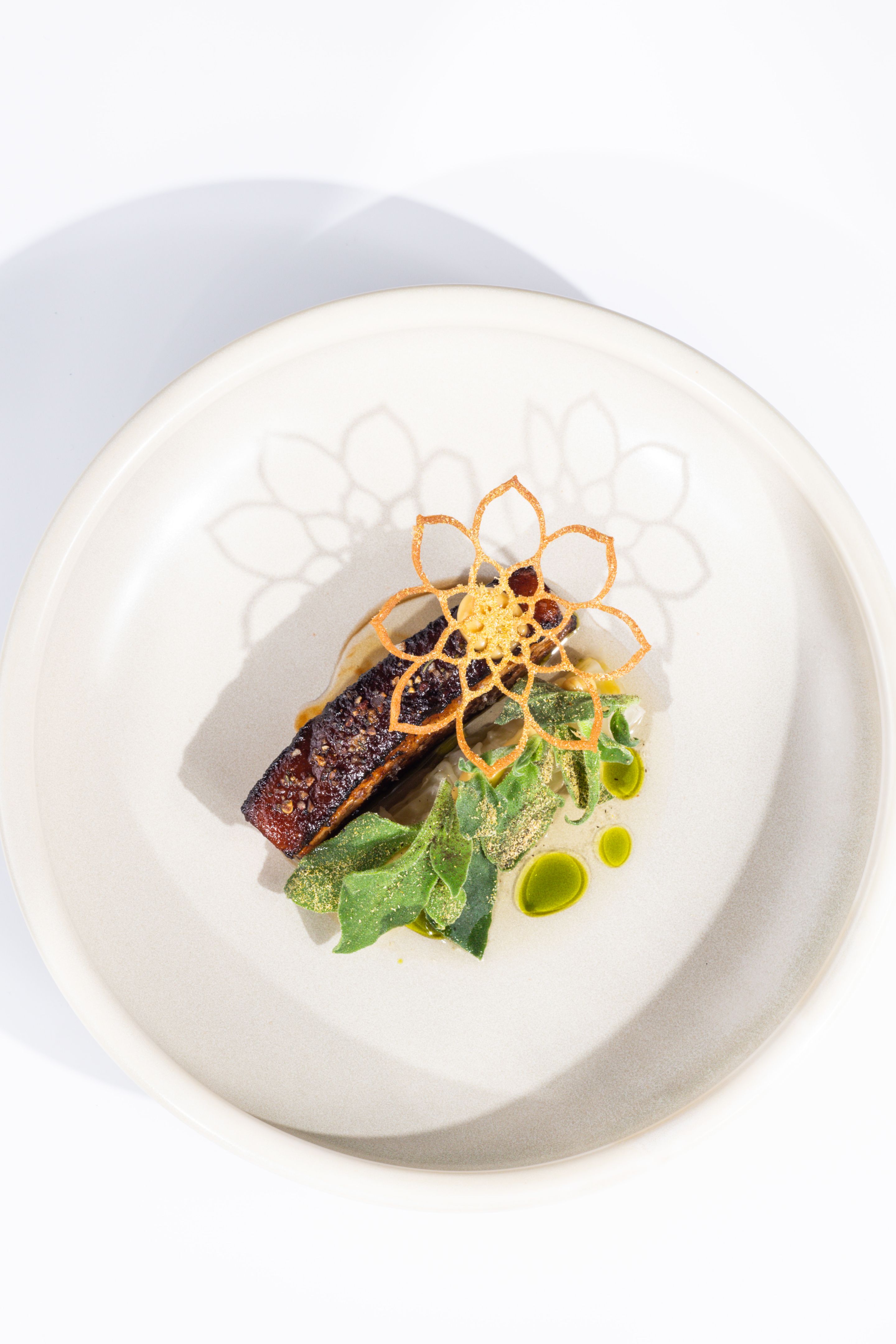Roast pork belly meat dish with sage butter and dill oil at Michelin star gourmet restaurant
