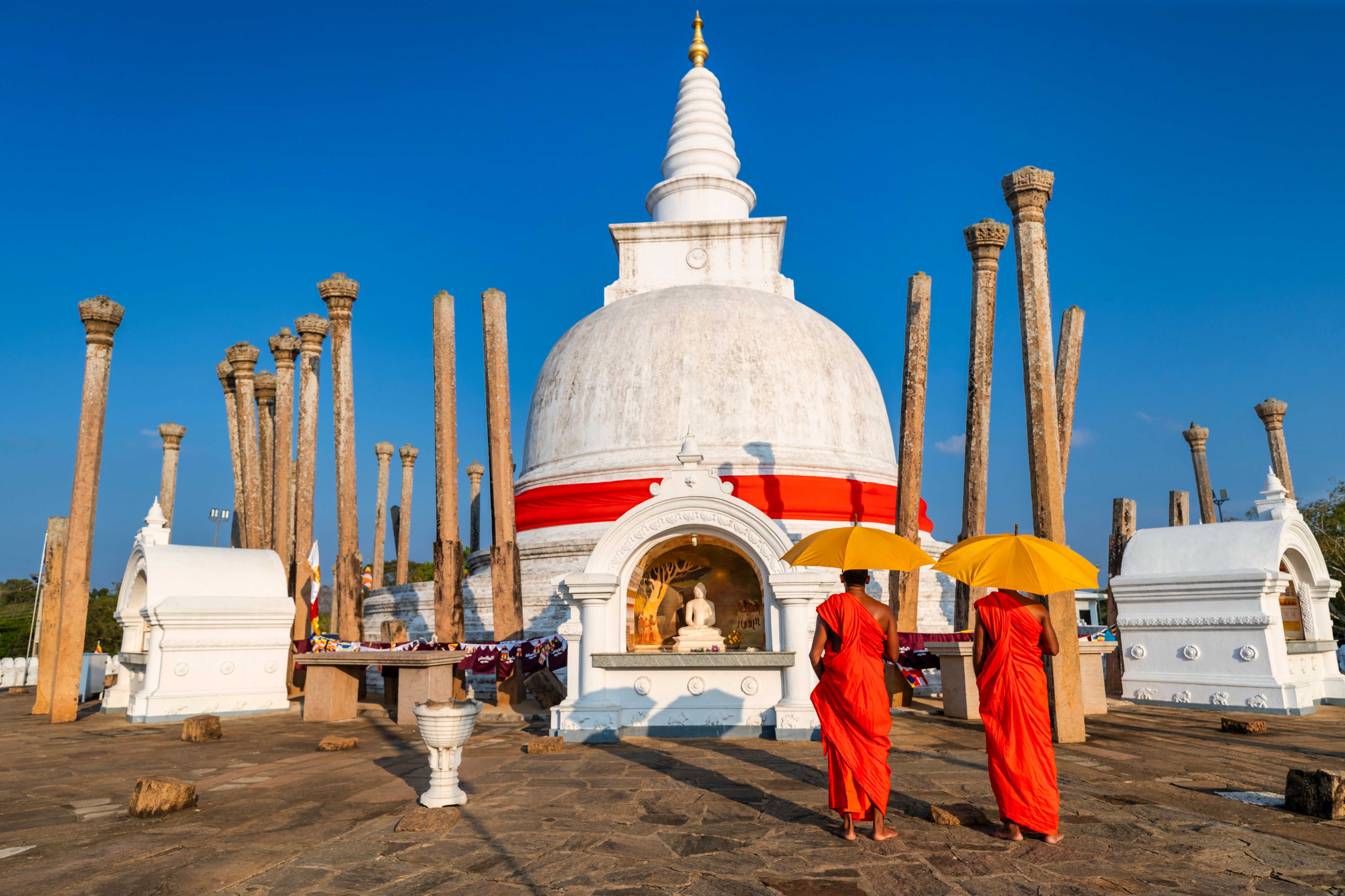 Sri Lankan buddhist monks walking inside an ancient temple, Ceylon