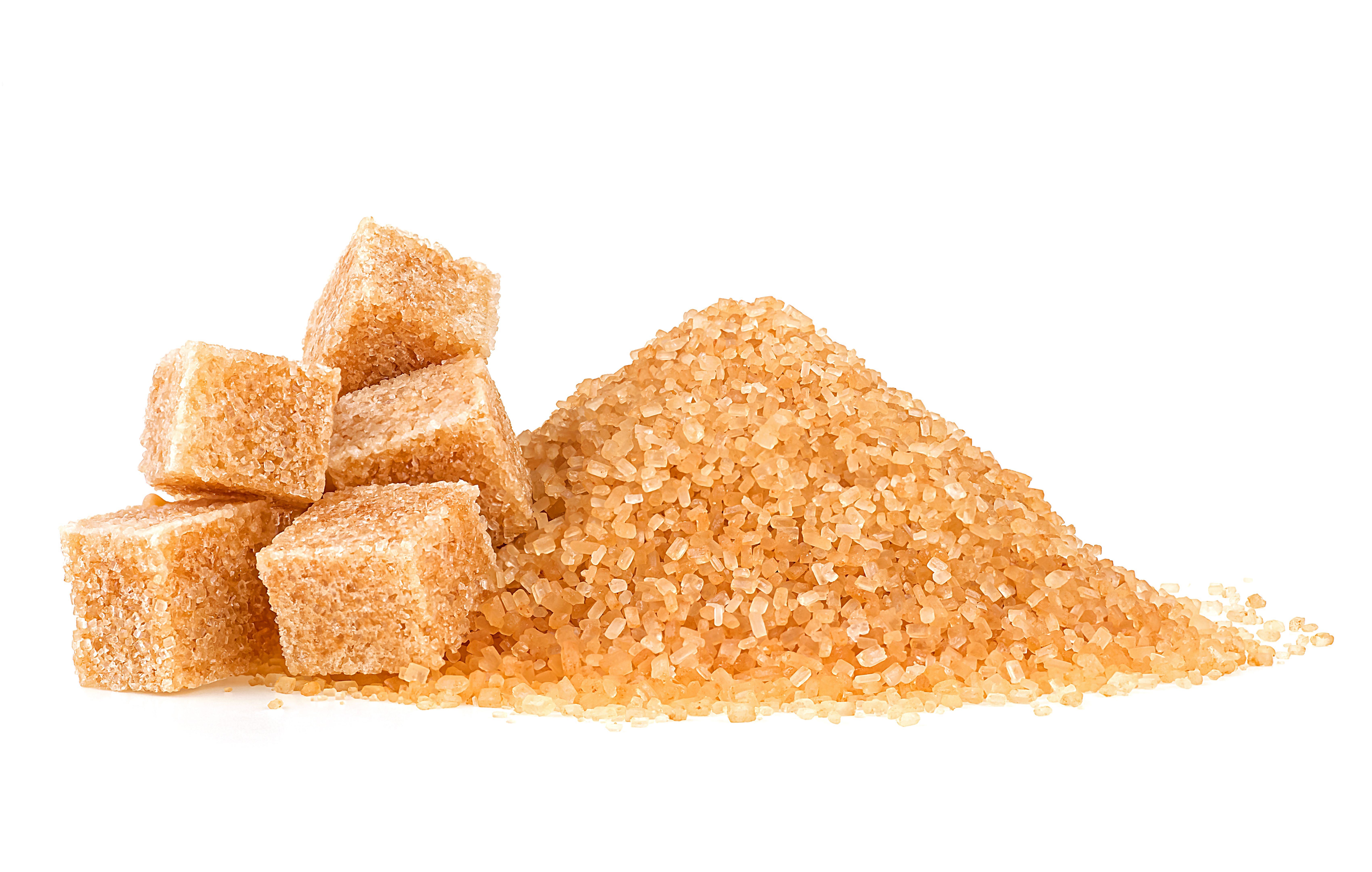Pile of brown granulated sugar and sugar cubes isolated on a white background. Unrefined brown cane sugar pile. Pile of brown granulated sugar and sugar cubes isolated on a white background. Unrefined brown cane sugar pile.