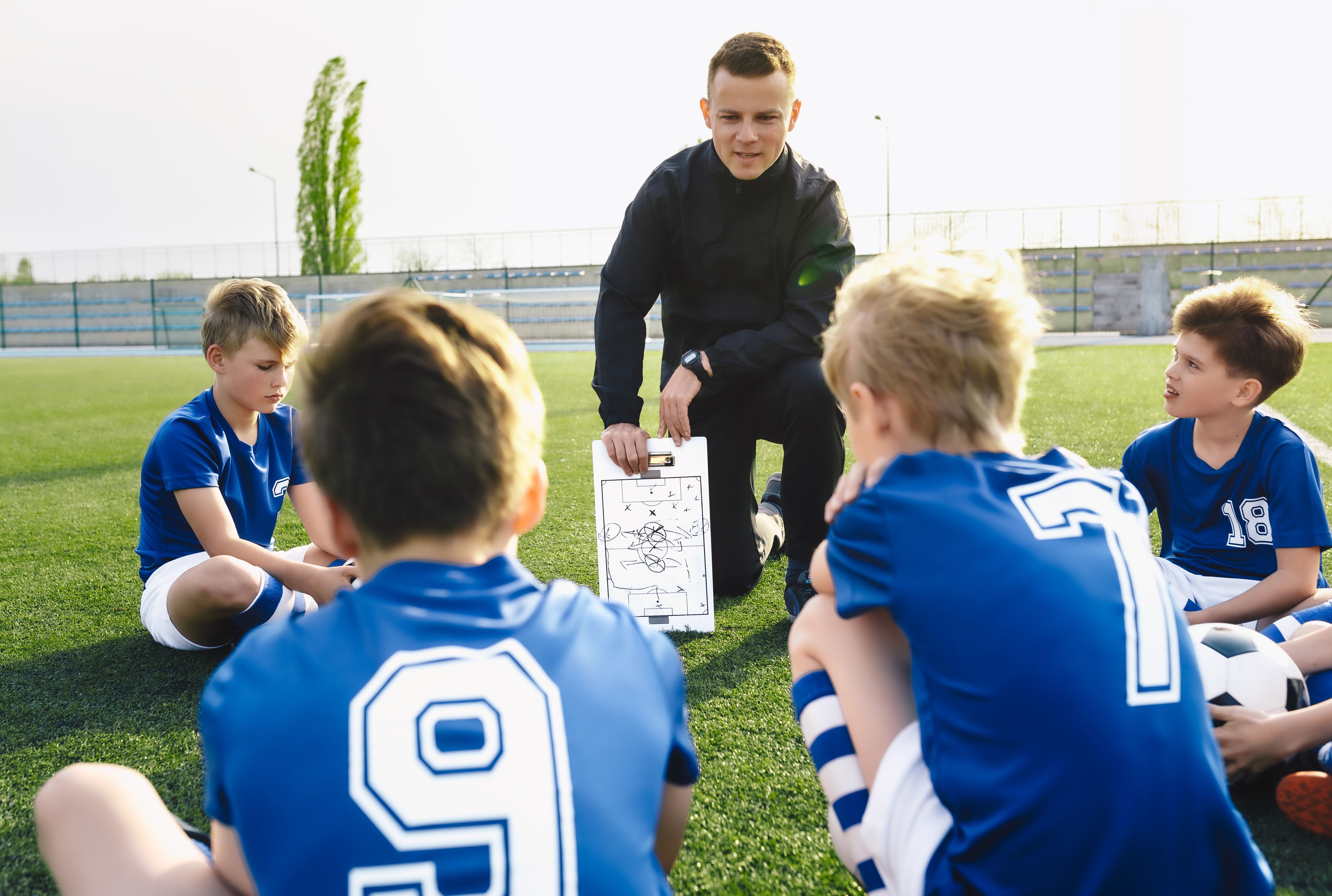 coach teaching soccer