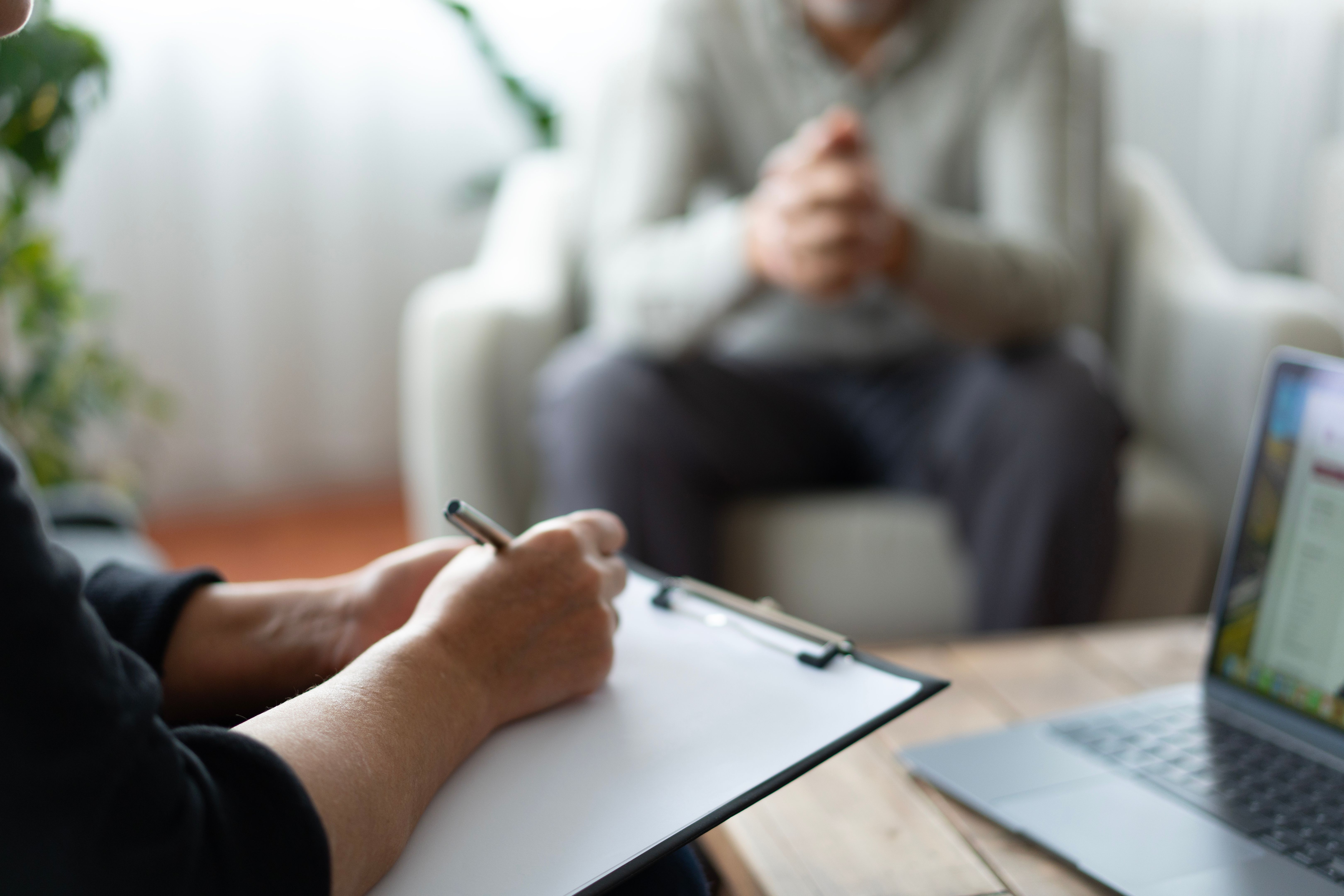 Le thérapeute prend des notes tout en écoutant le patient pendant la séance de thérapie