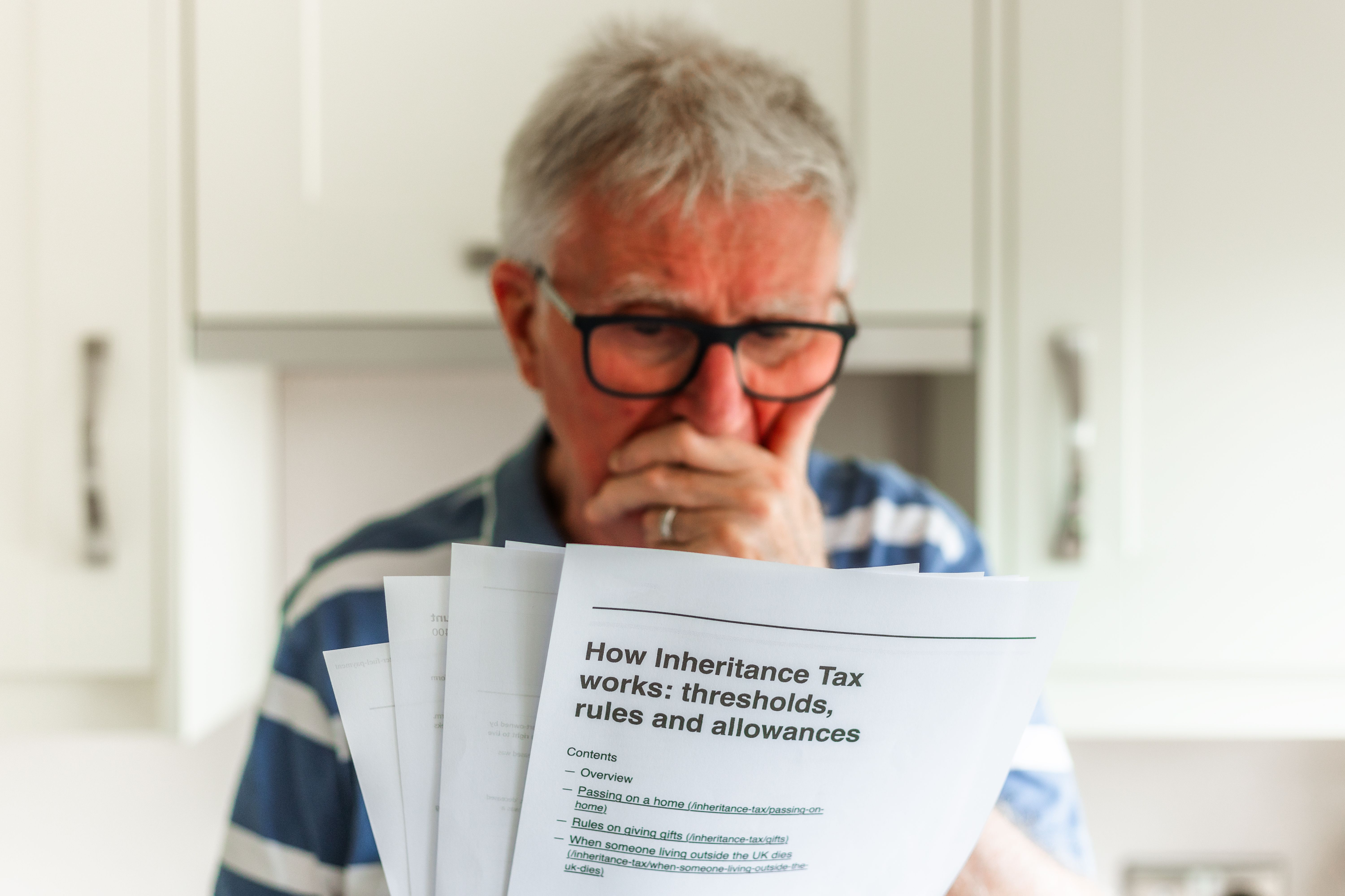 Worried senior man looking at inheritance tax documents