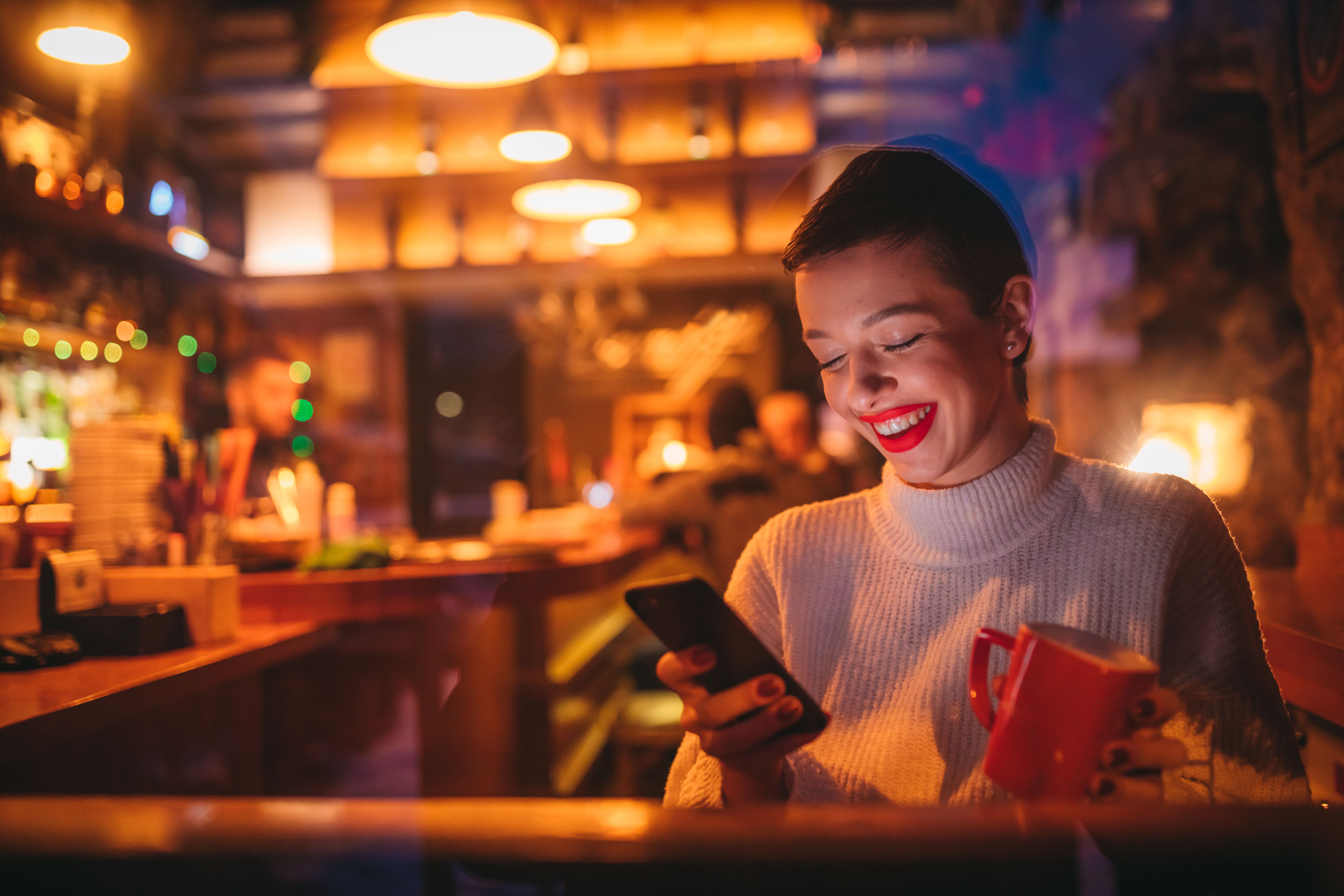 College student drinking coffee at cafe and using phone College student drinking coffee at cafe and using phone