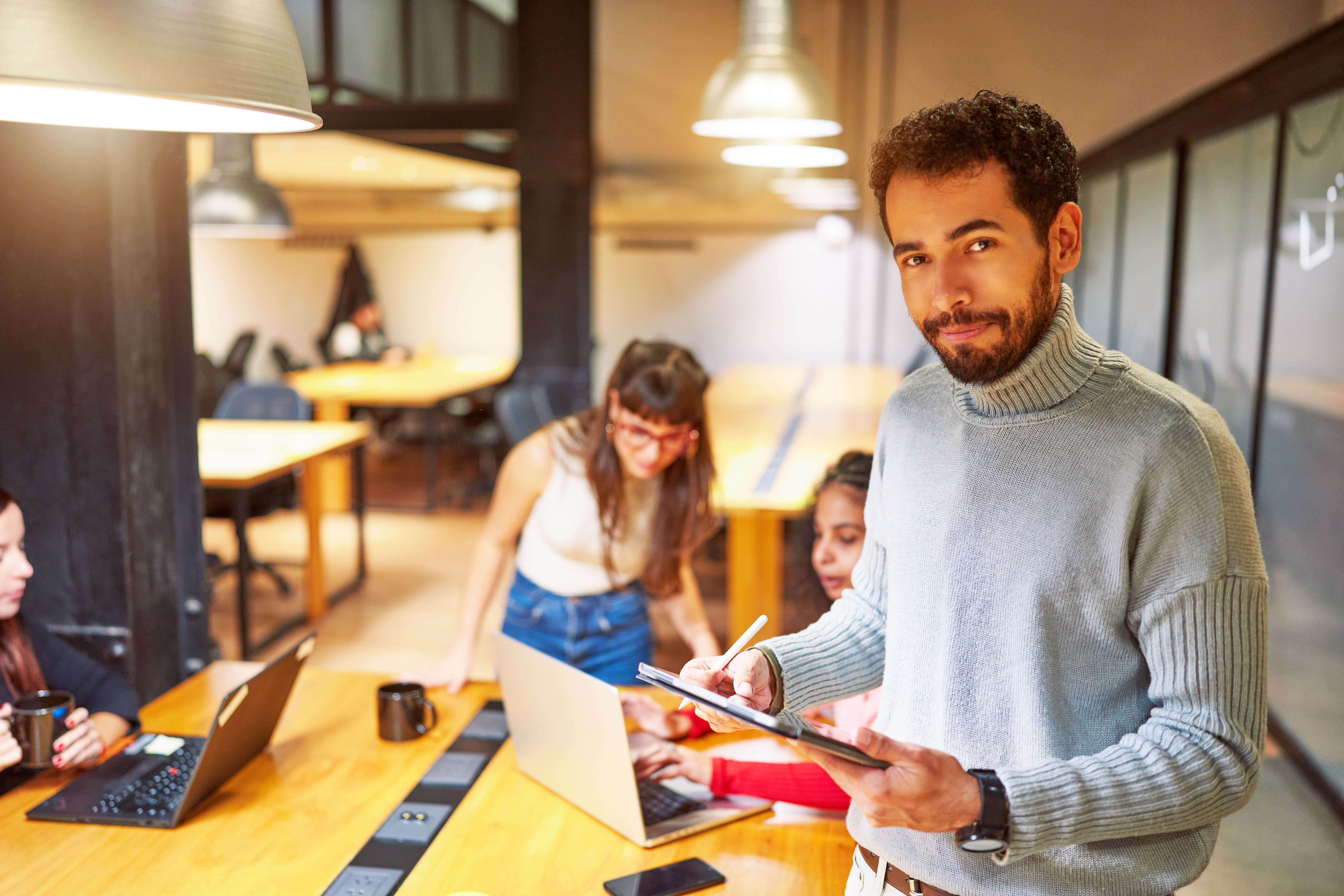 portrait cheerful young Latin American businessman or employee looking at camera in meeting room