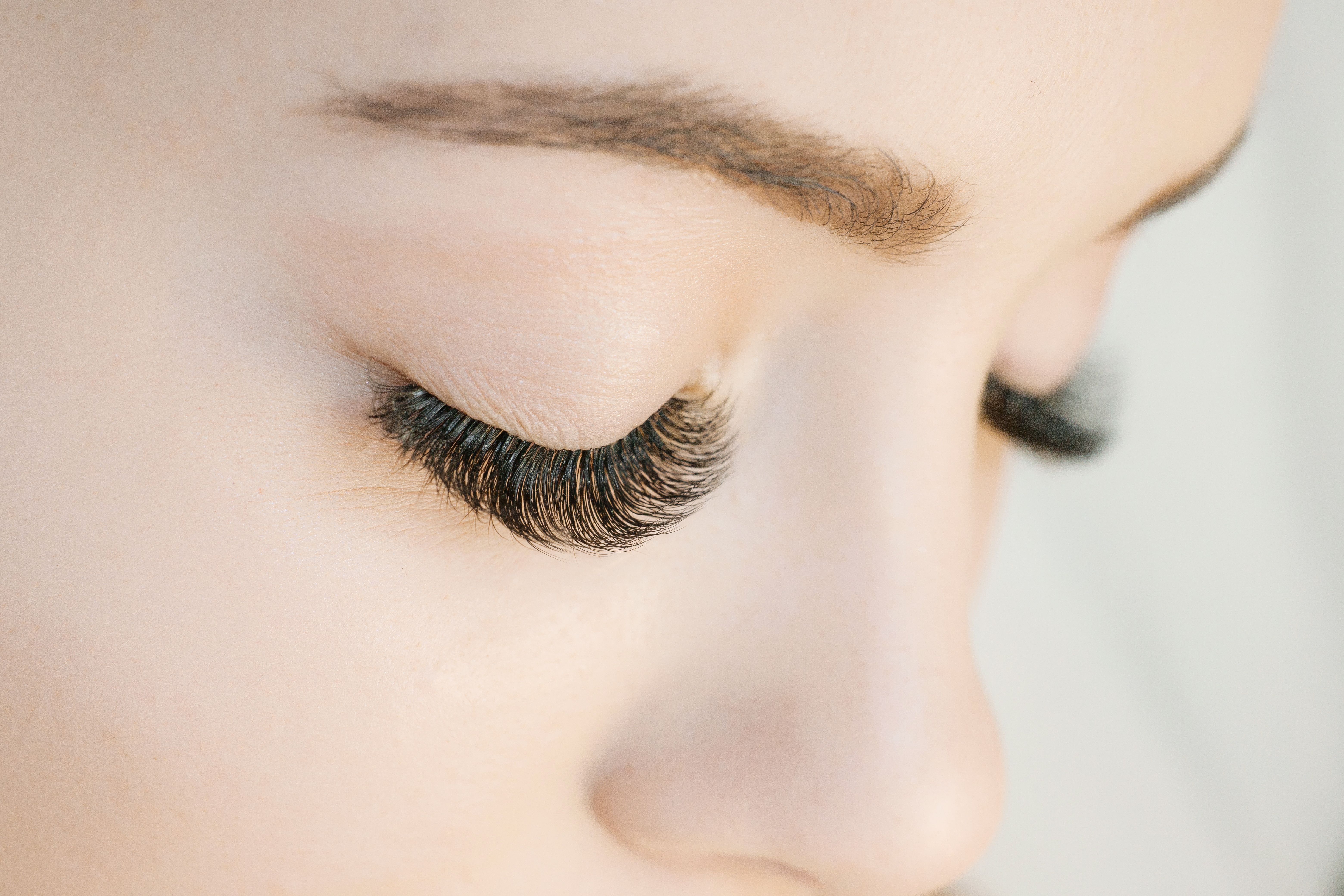 Eyelash extension procedure. Close up view of beautiful woman eyes with long eyelashes. Lengthening lashes for girl in a beauty salon. Beauty concept. Eyelash extension procedure. Close up view of beautiful woman eyes with long eyelashes. Lengthening lashes for girl in a beauty salon. Beauty concept.