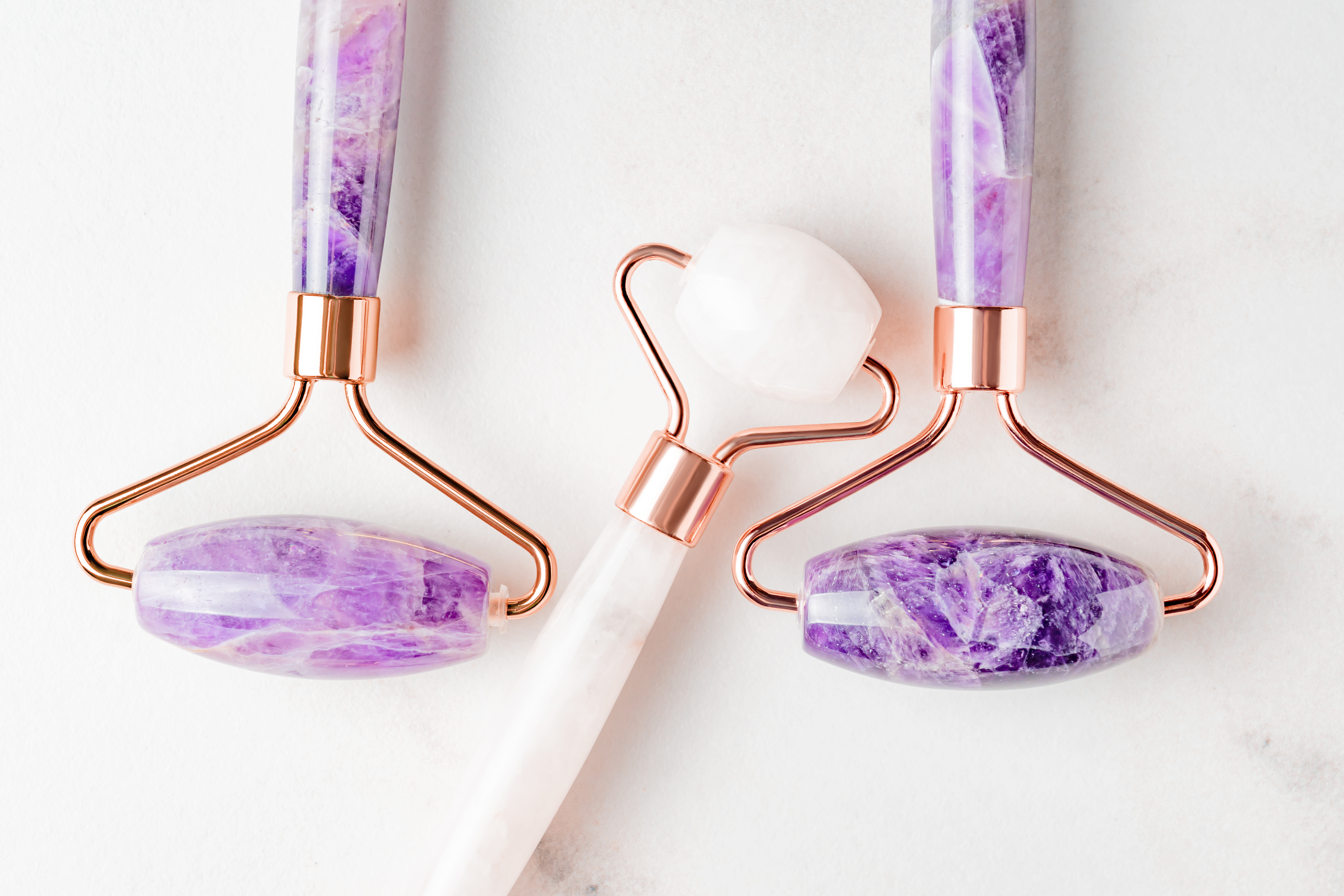 Face roller guasha massagers. Face skin care and anti age products. Chinese Gua Sha massage tools from rose quartz and ametyst. Close up, top view