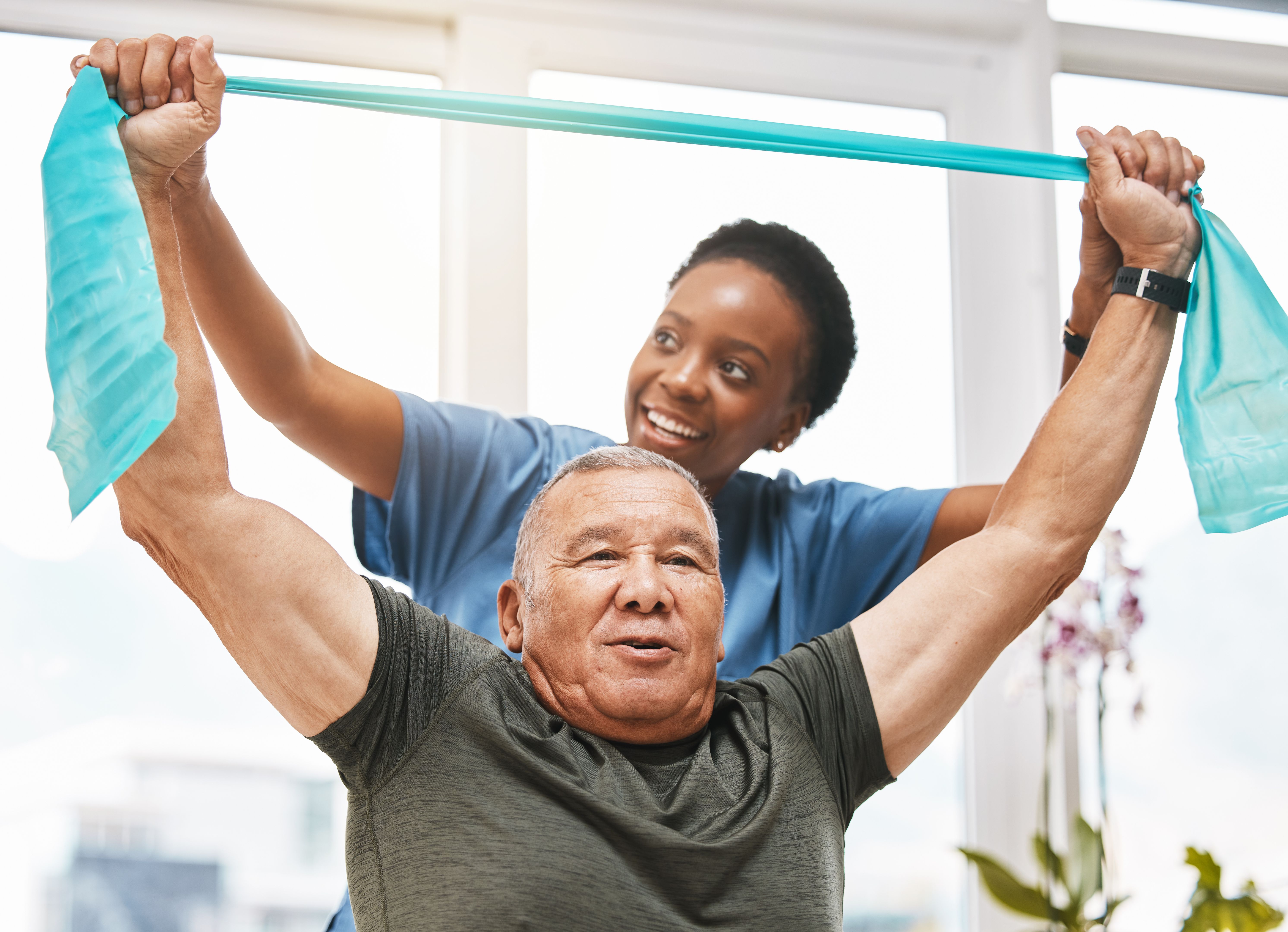 Physiotherapy help, stretching band and doctor with senior man in physical therapy, rehabilitation or healthcare support. Black woman chiropractor or physiotherapist consulting elderly patient
