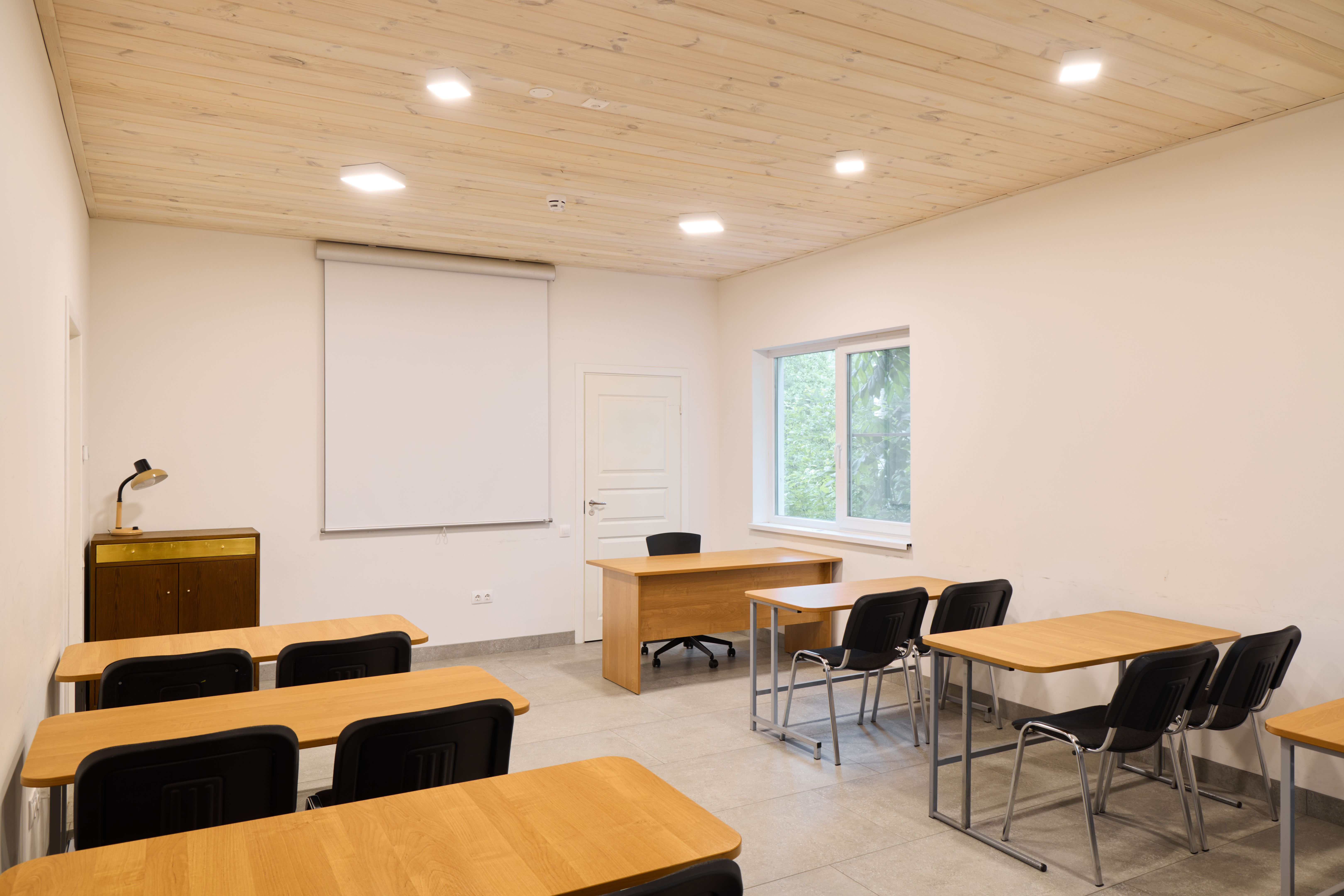 A modern classroom with desks, cozy seating, and a projector for presentations and lectures