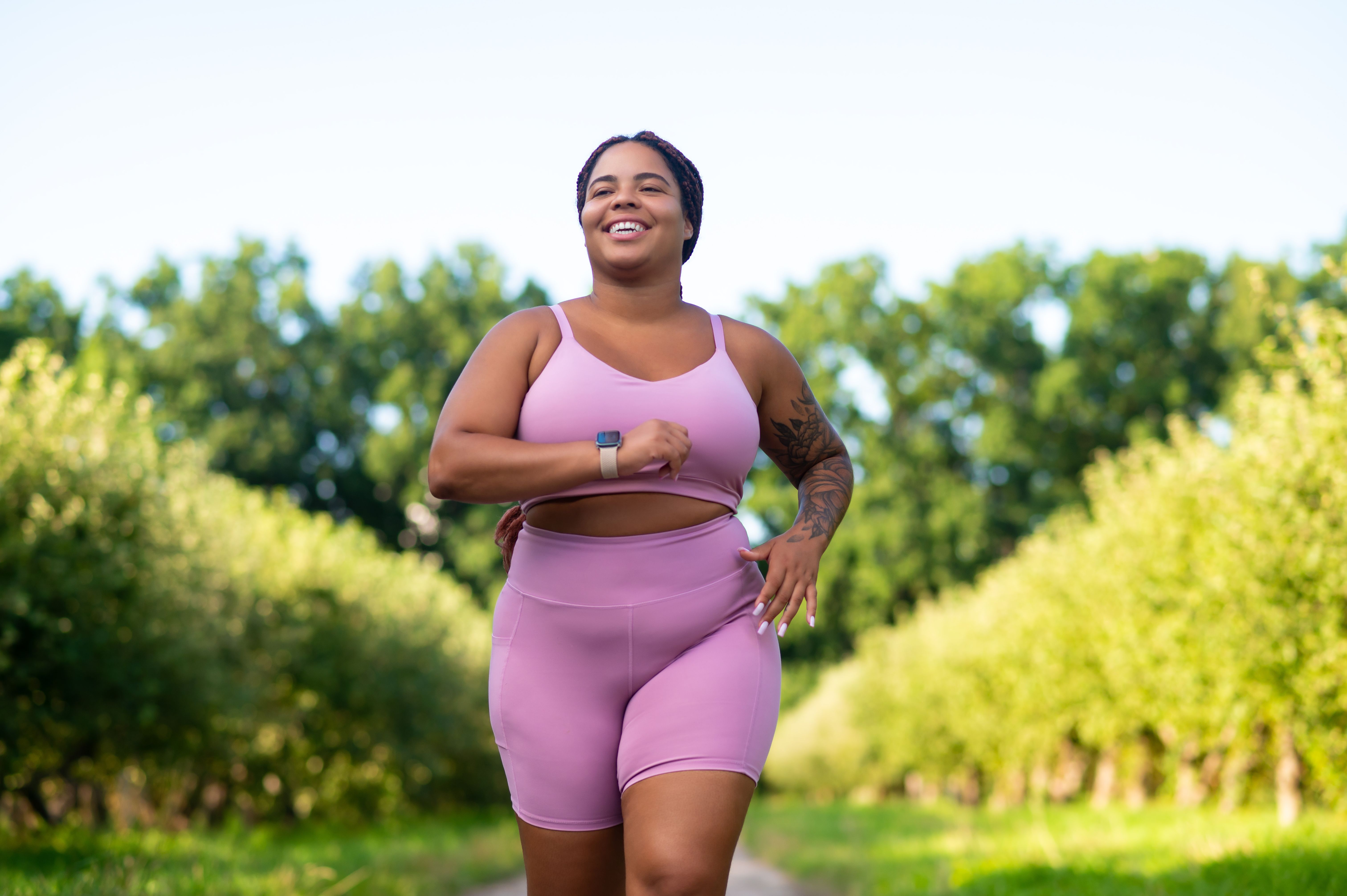 Plus size female athlete jogging on sports ground