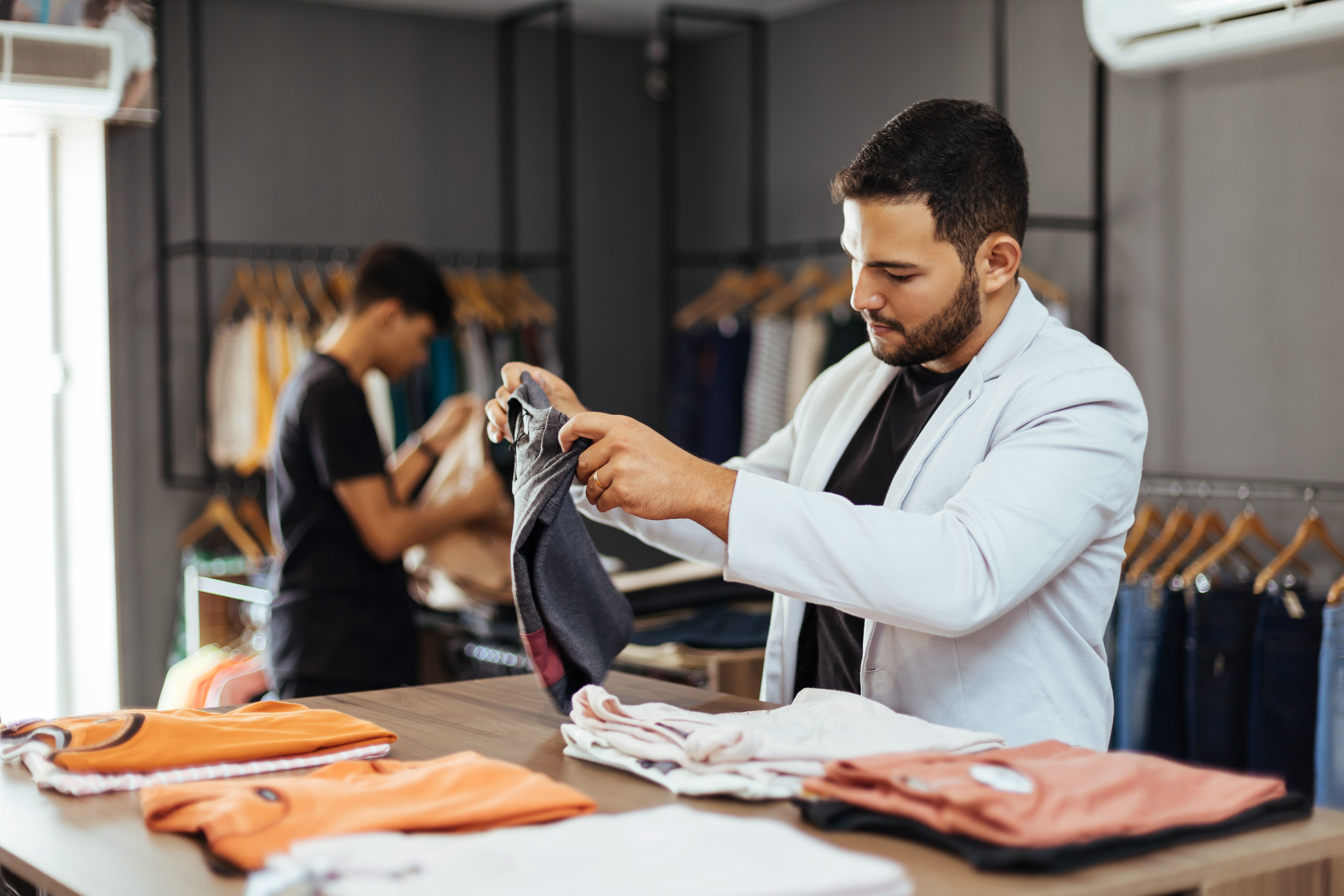 Small business. Men's clothing and accessories store. Owner organizing the products.