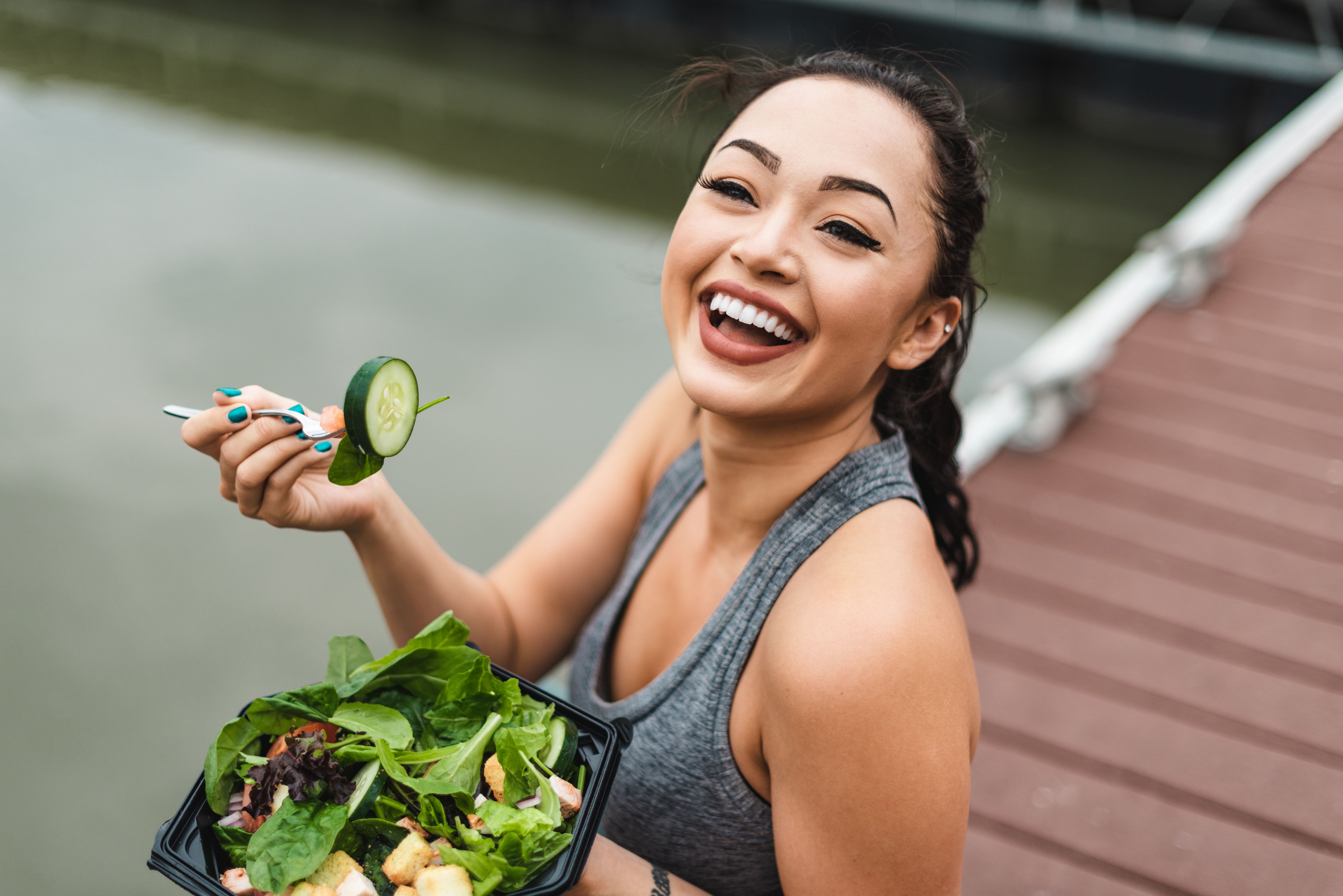fitness woman eating an healthy salad and smiling fitness woman eating an healthy salad and smiling