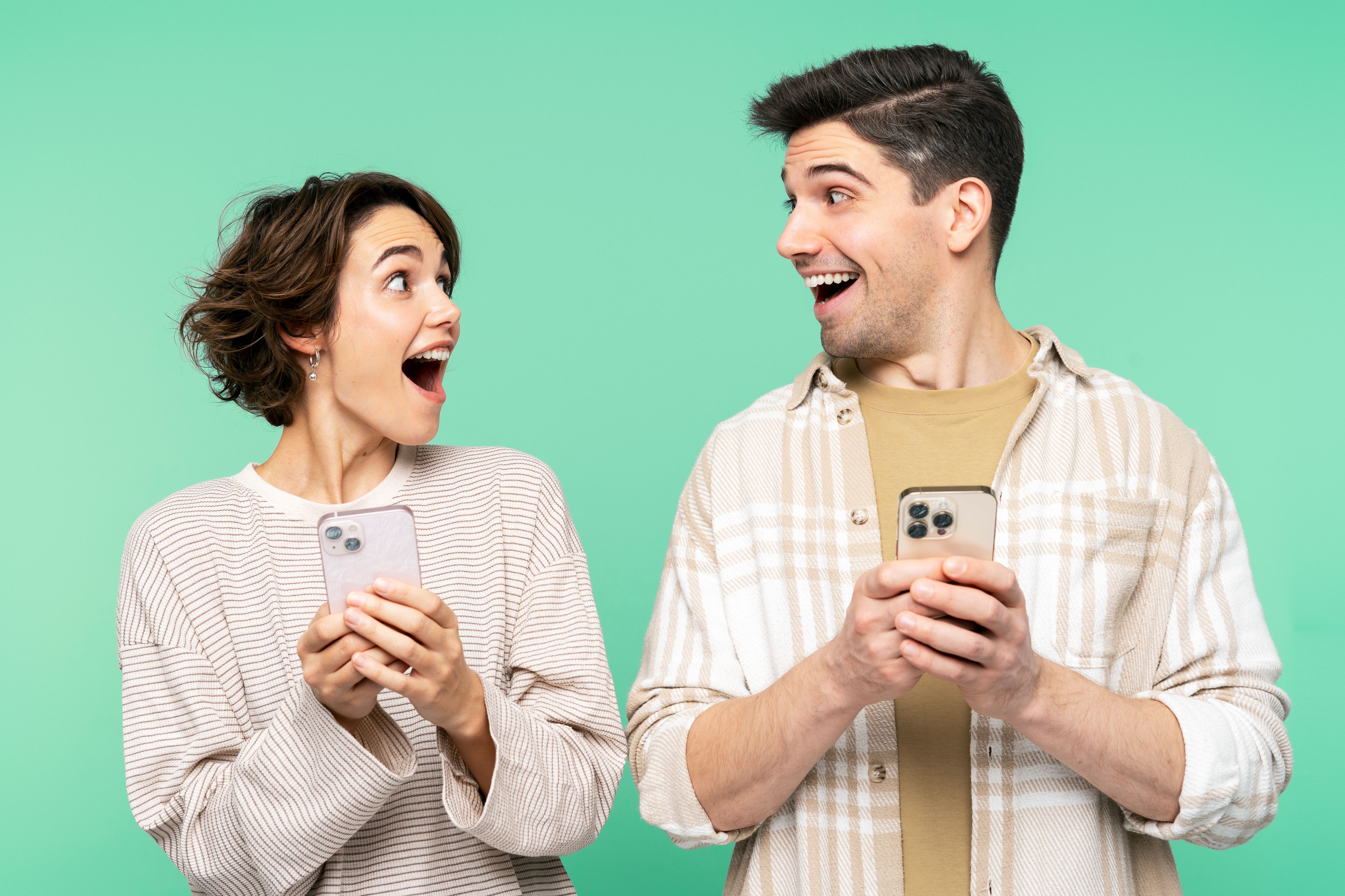 Smiling shocked people holding mobile phones, looking each other, and screaming
