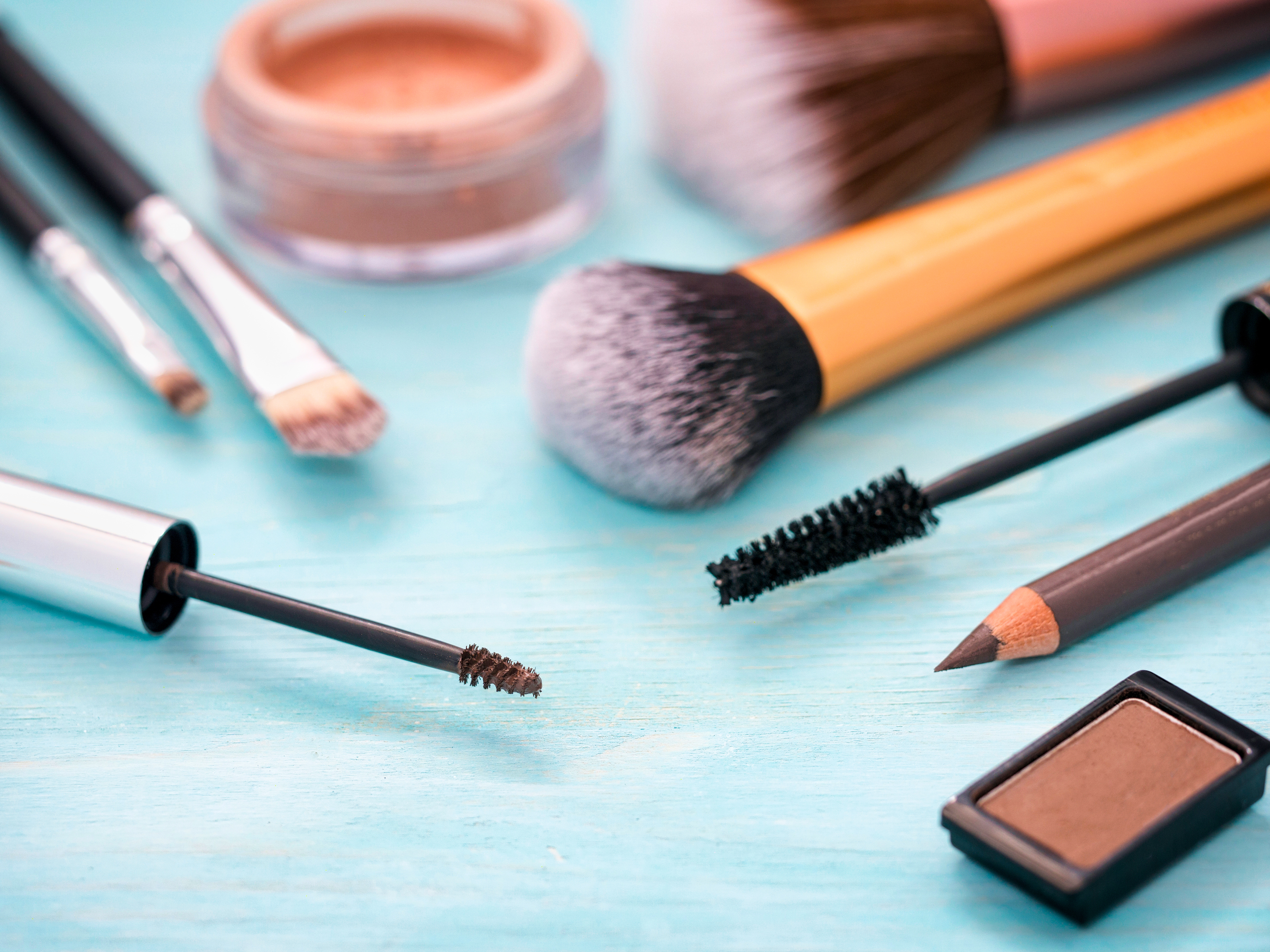 Set of makeup on turquoise wooden background