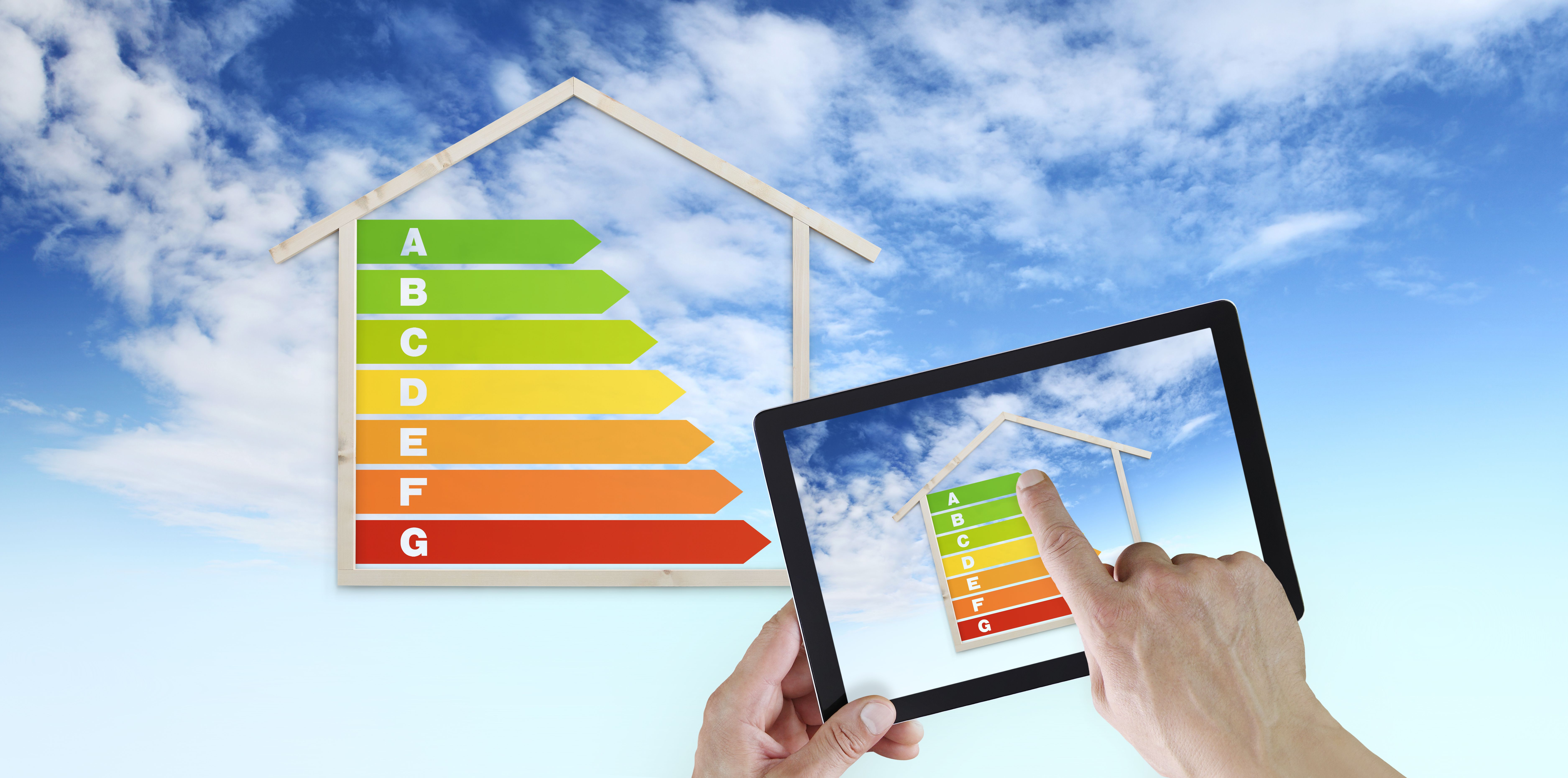 hand touch screen of digital tablet with house shape and energy efficiency chart symbol, isolated on blu sky background, green buildings and save energy eco sustainability