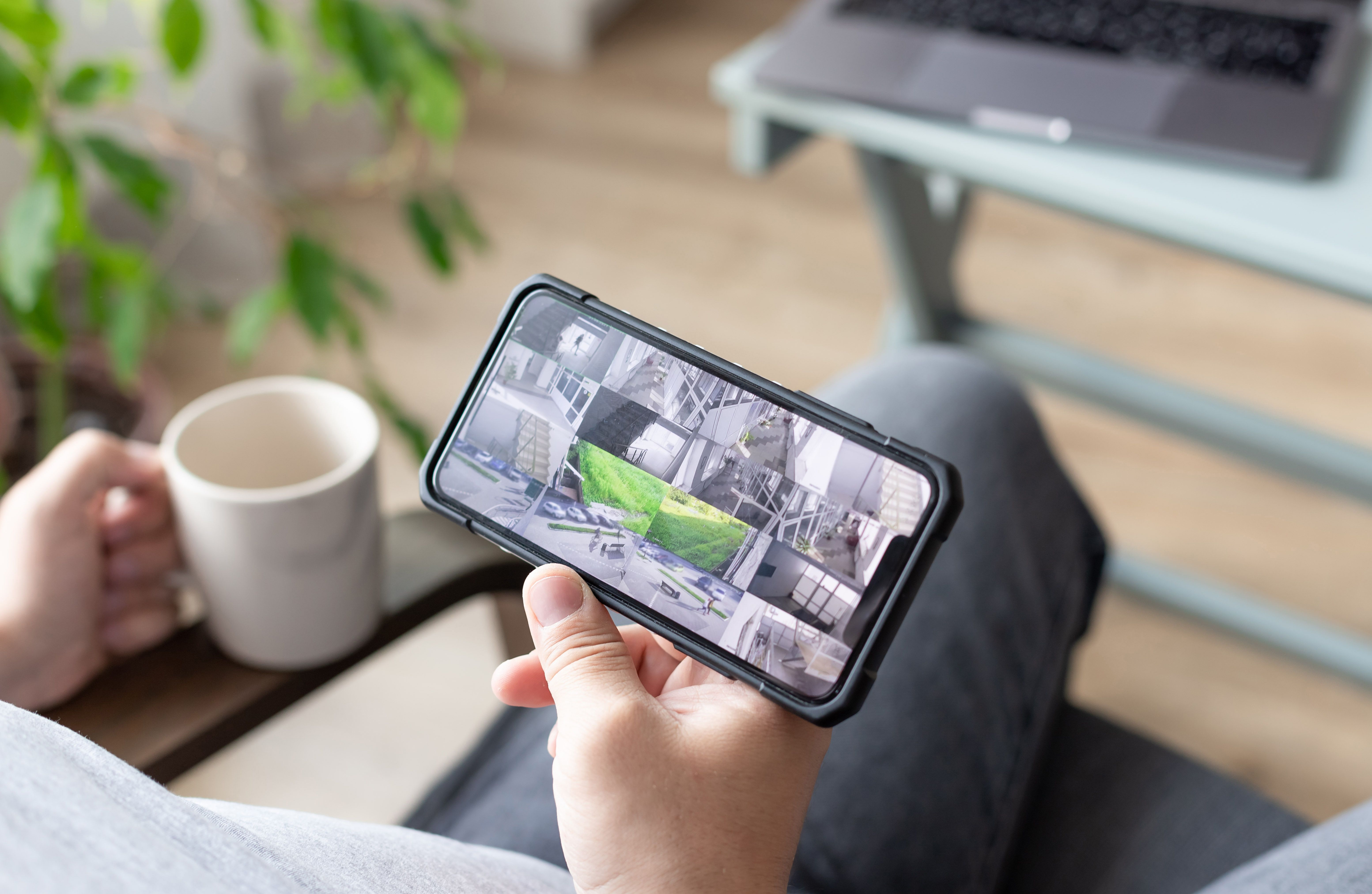 person hand holding smartphone with multiple camera views