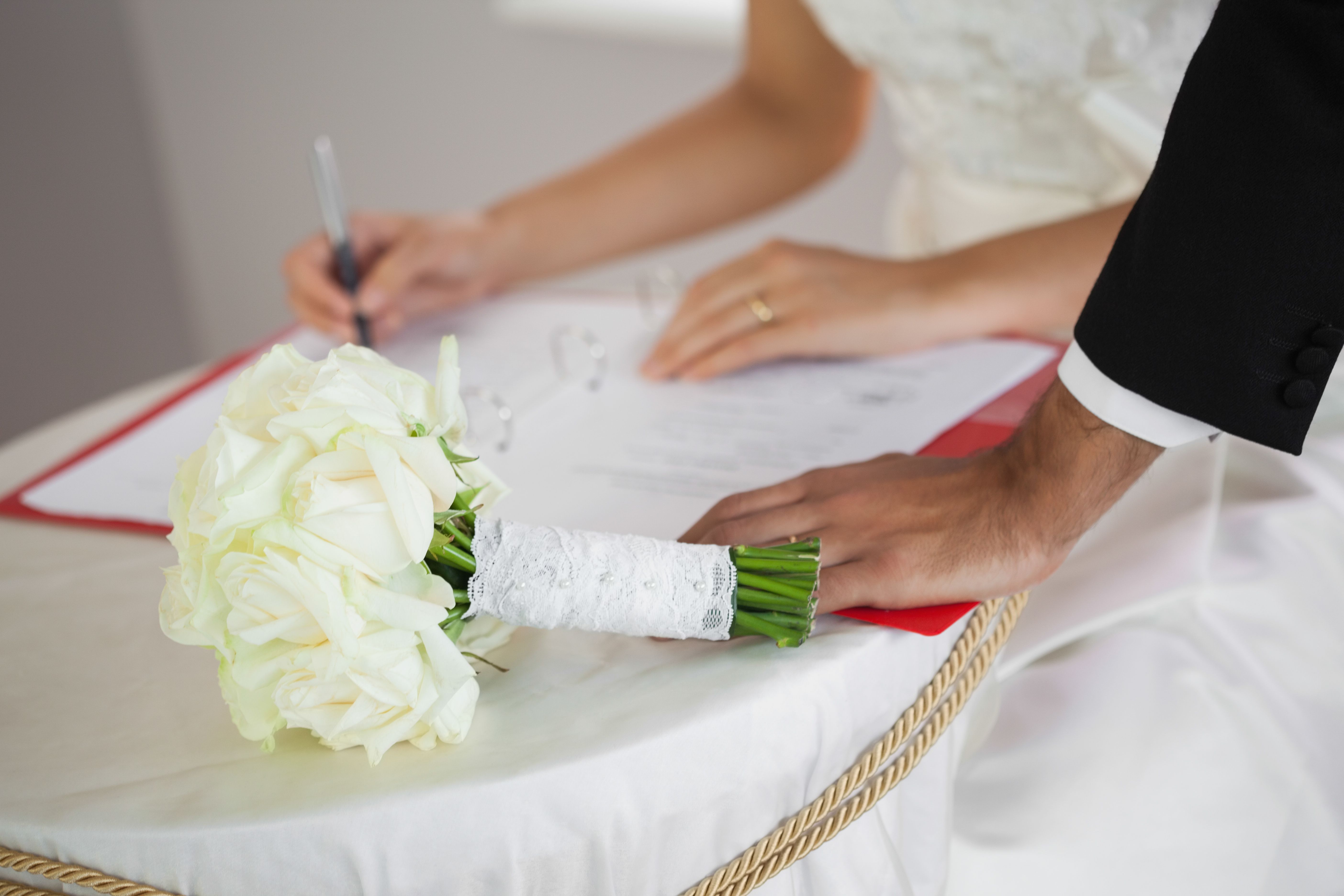 Close up of an attractive couple signing wedding register