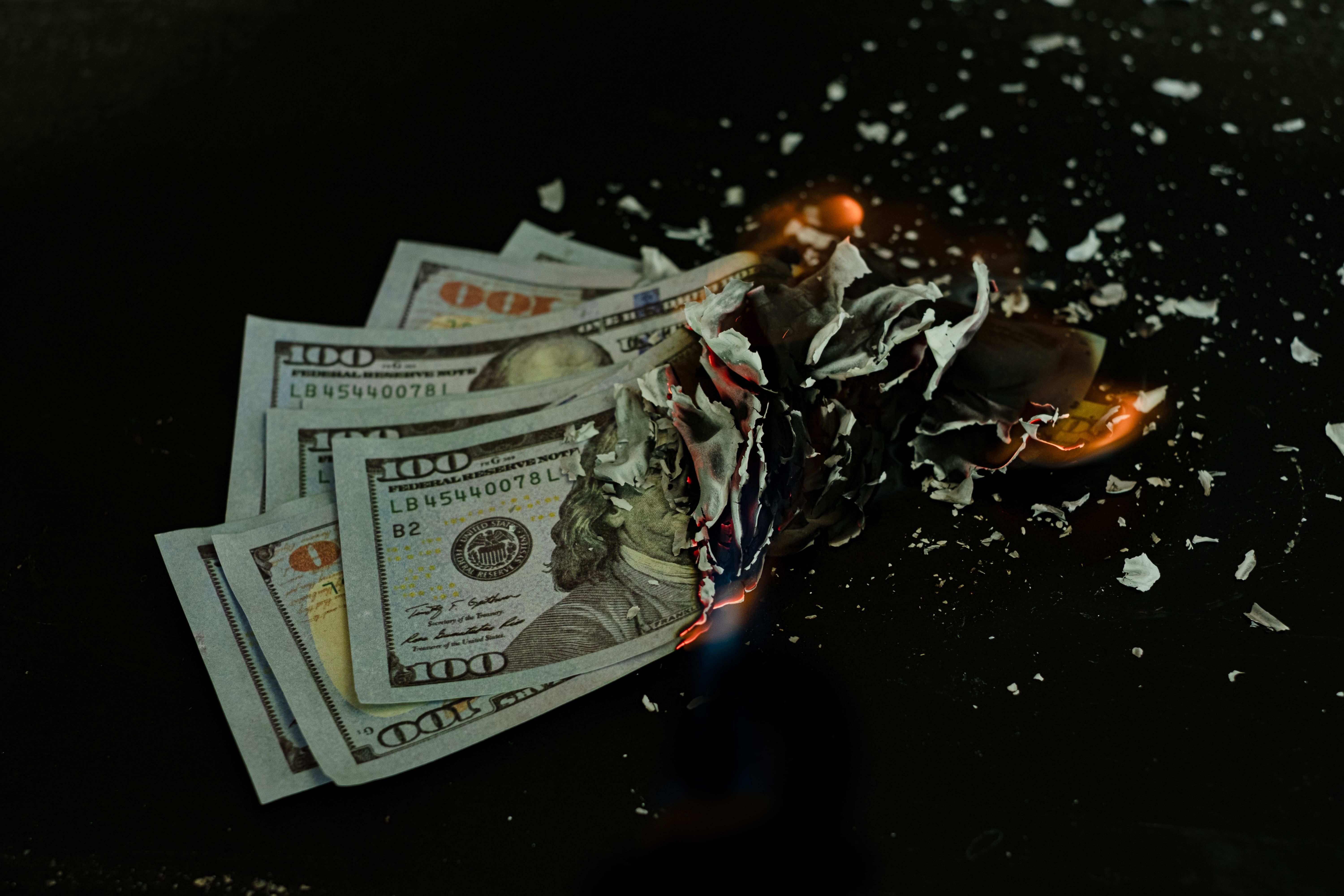 Stack banknote is burning on a black background, symbolizing business payment and financial success Stack banknote is burning on a black background, symbolizing business payment and financial success