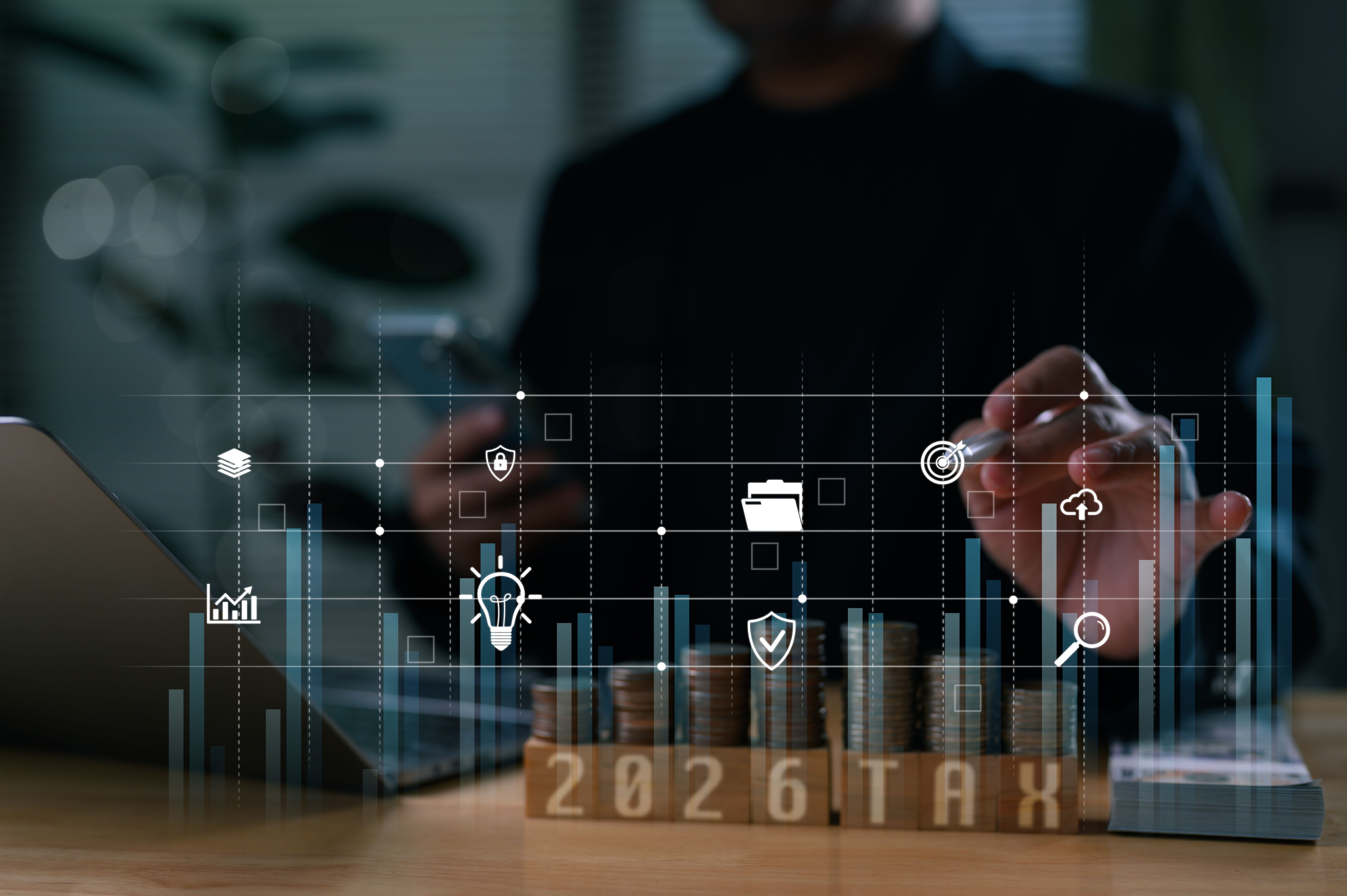 Businessman planning 2026 tax year, interacting with futuristic virtual interface showing data analytics. Concept represents financial management, investment growth, new technology, future business