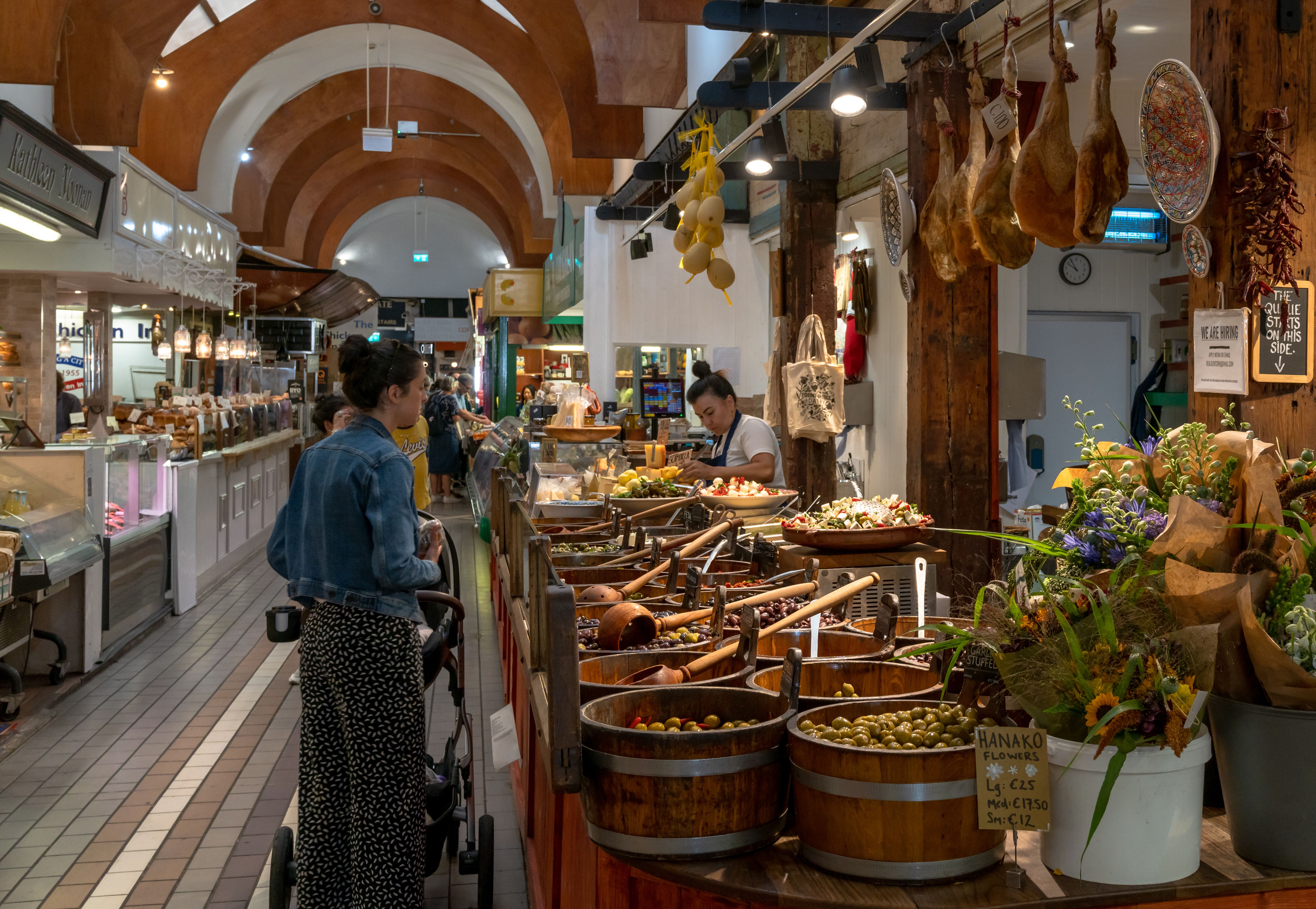 customers buying food at a market stall with Spanish delicacies and Iberico Hams