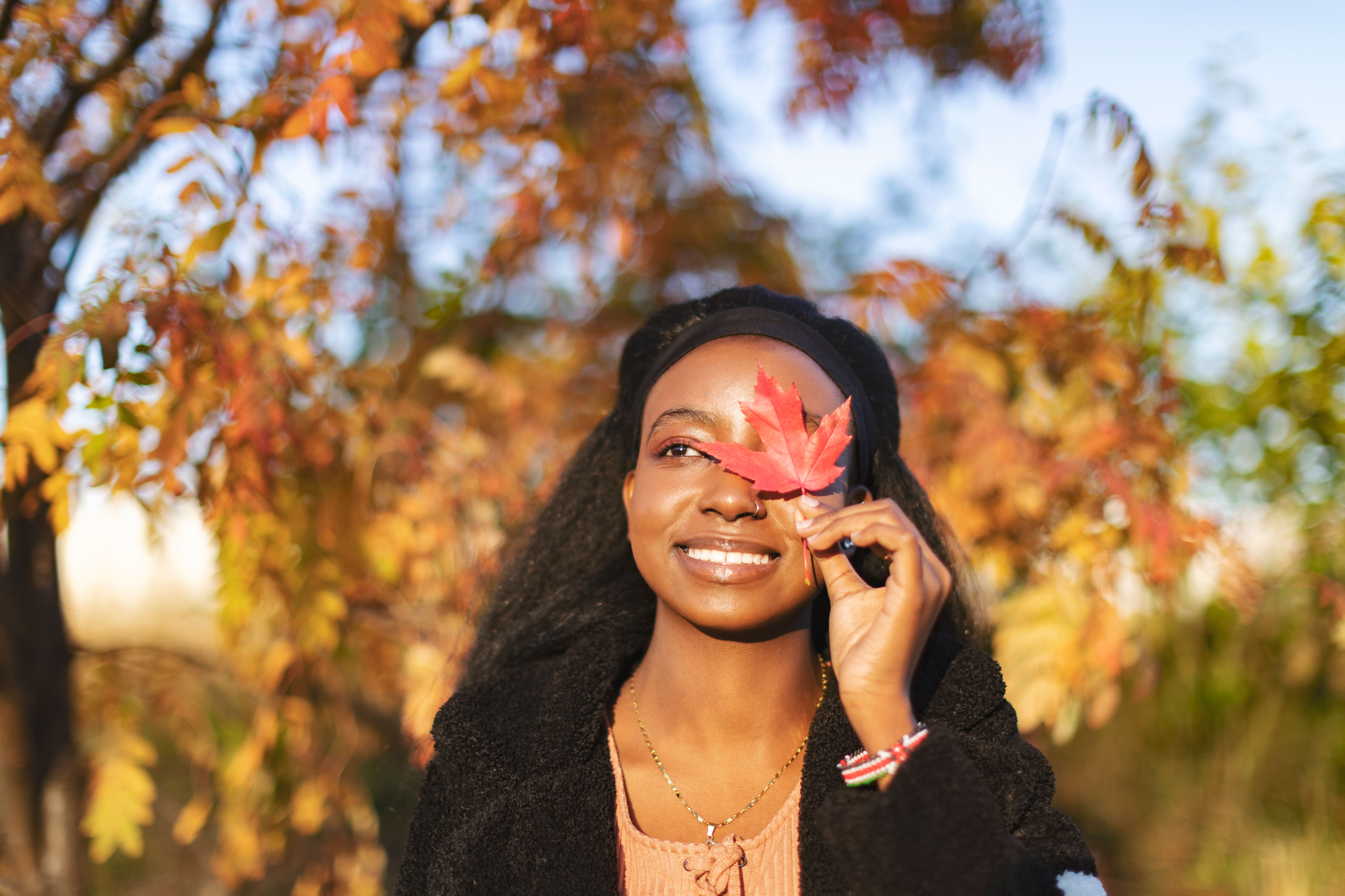 Young adult black woman enjoying autumn nature in public park Young adult black woman enjoying autumn nature in public park