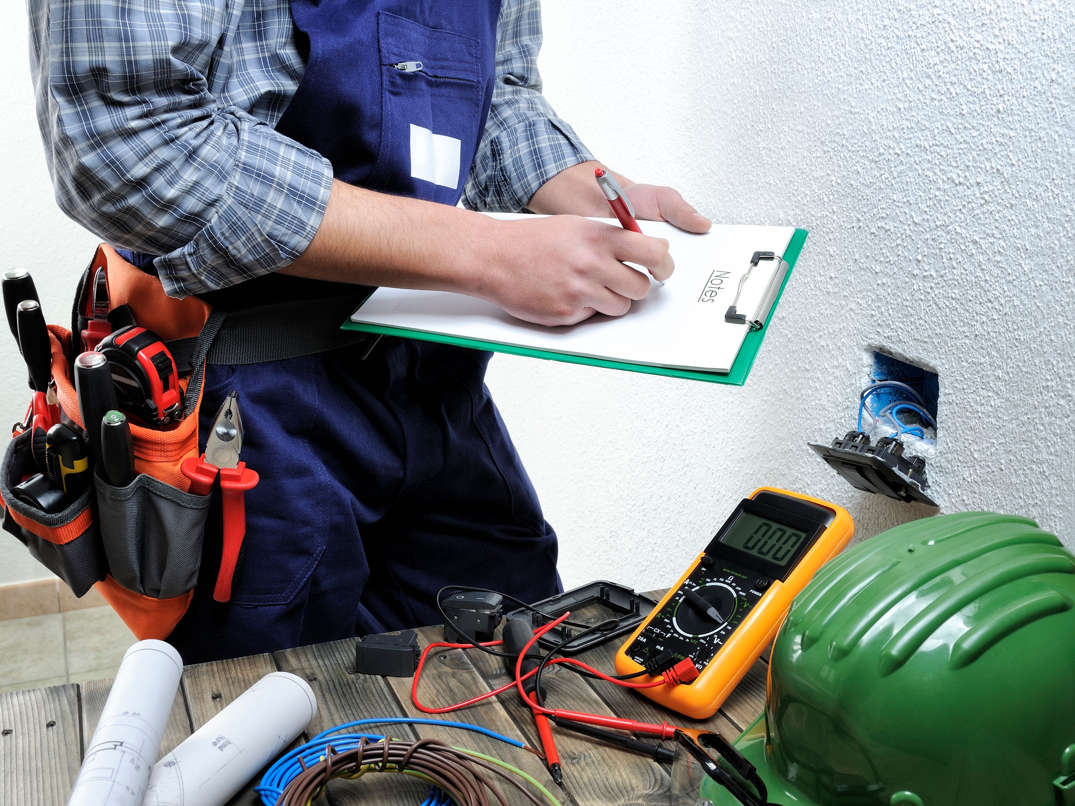 Young electrician working in a residential electrical installation Young electrician working in a residential electrical installation