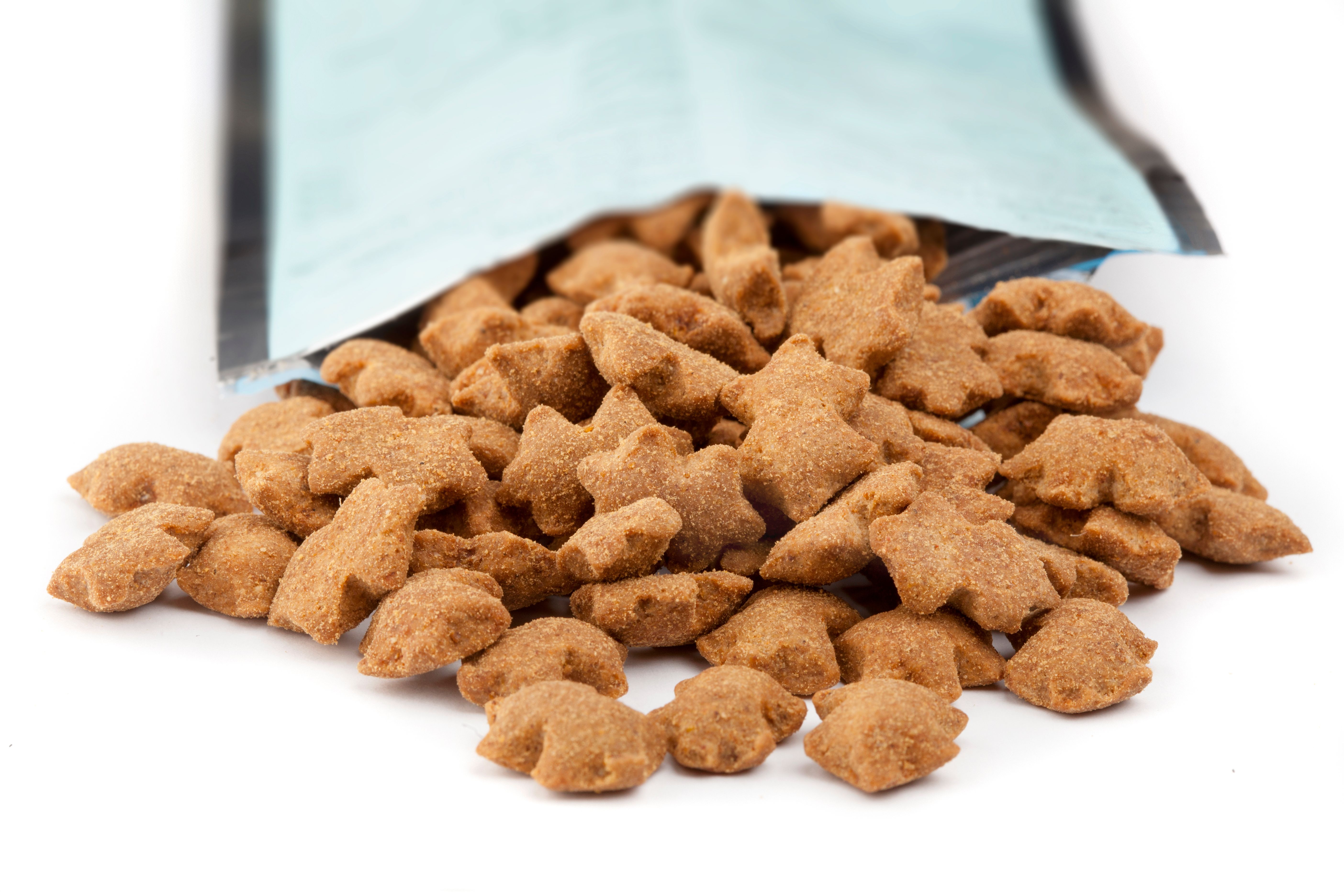 Heap of brown cat dry food falling out of bag Heap of brown cat dry food falling out of bag