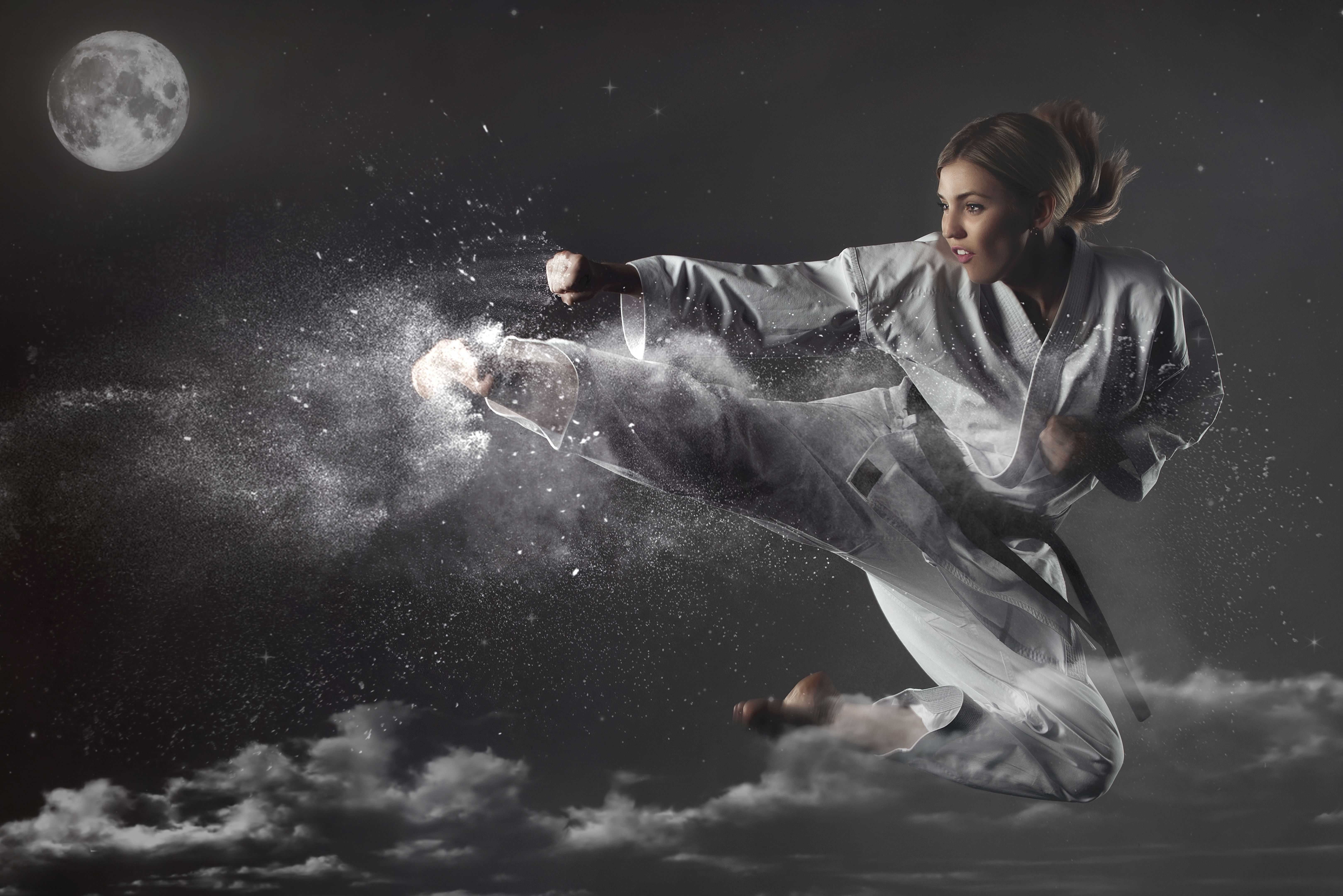 Young emotional karate girl tries to hit the moon