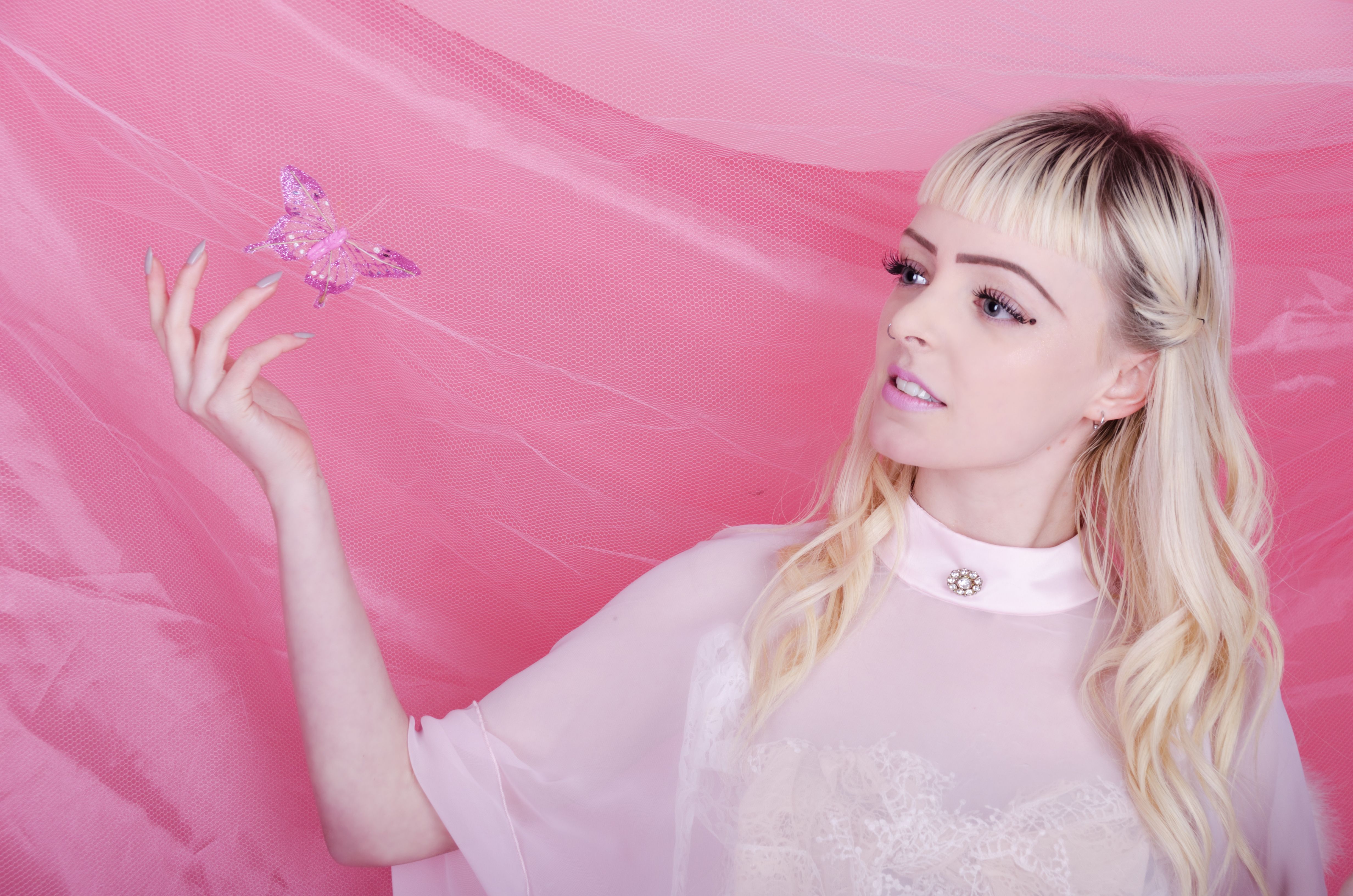 Young woman trying to catch butterfly.