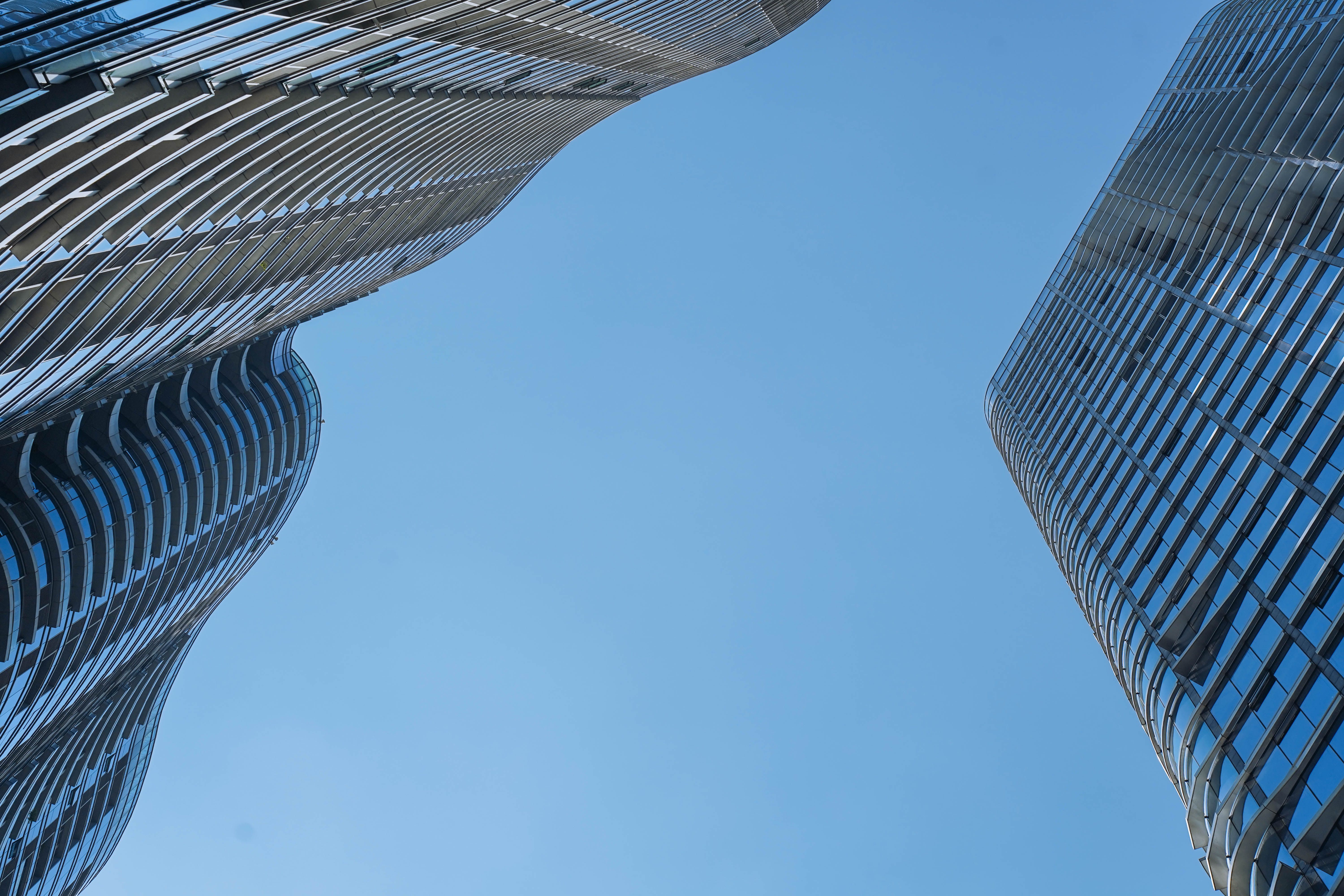 Low angle view of skyscraper with glass window and clear blue sky background for business and finance concept