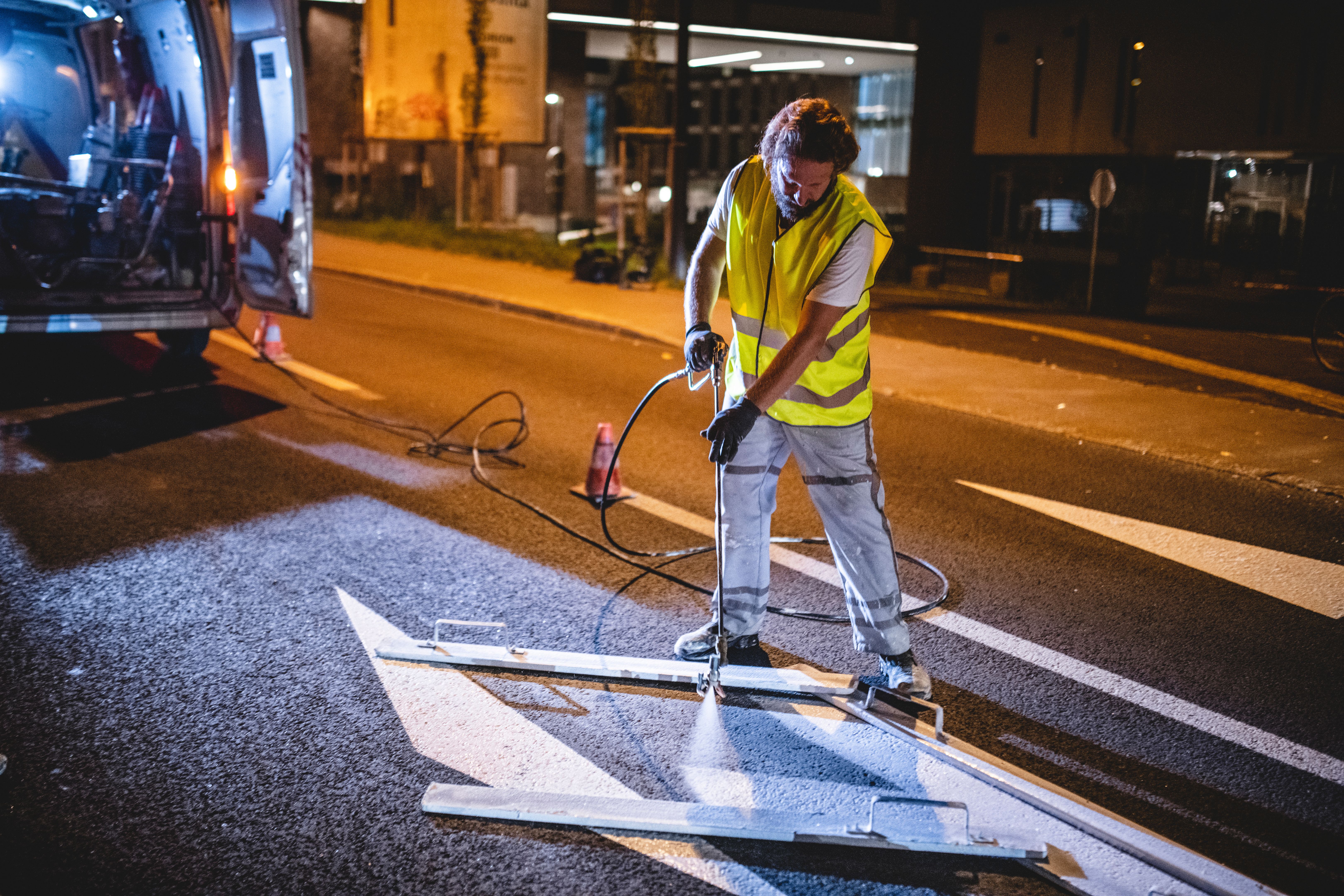 Nighttime Pavement Marking Crew Spray Painting Turn Arrow Nighttime Pavement Marking Crew Spray Painting Turn Arrow