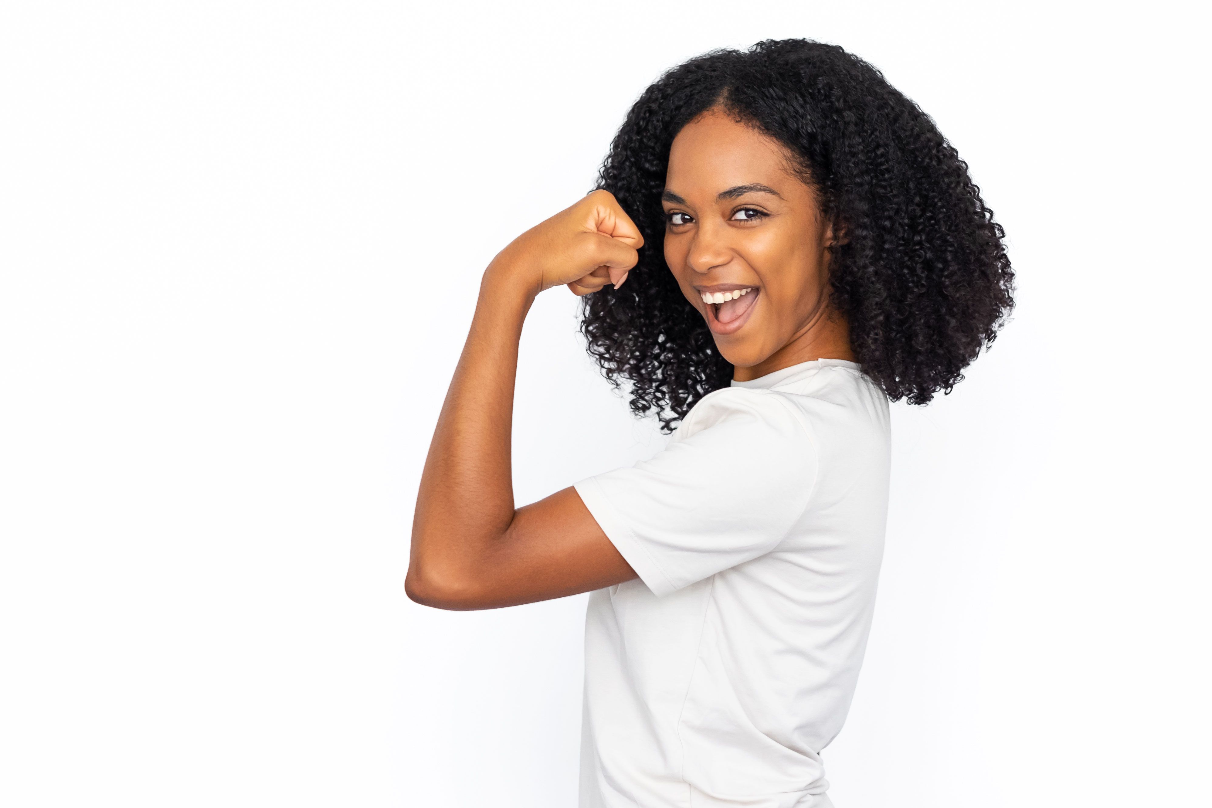 Happy African American woman showing bicep