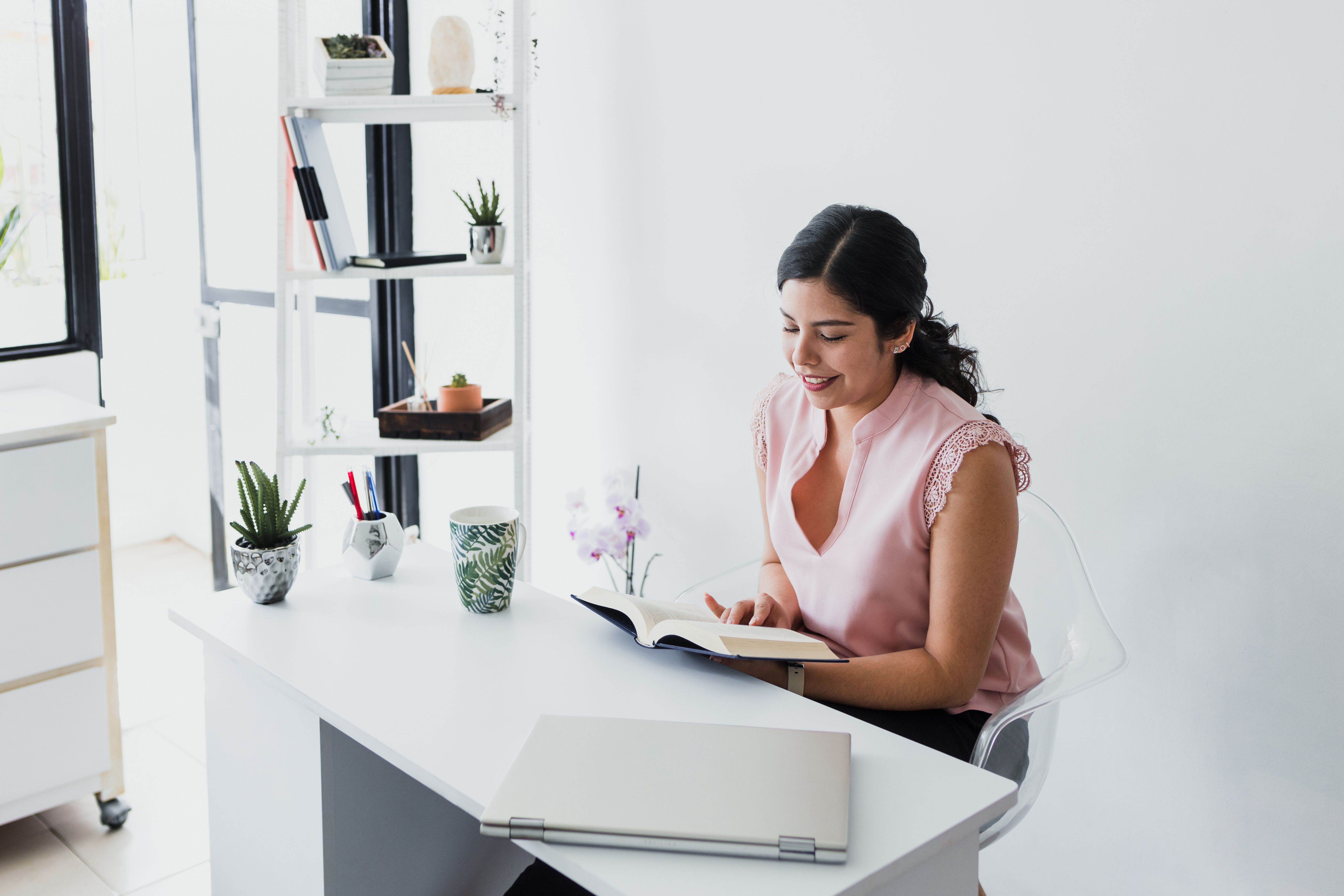 hispanic business woman reading a book in her desk at office in Mexico Latin America hispanic business woman reading a book in her desk at office in Mexico Latin America