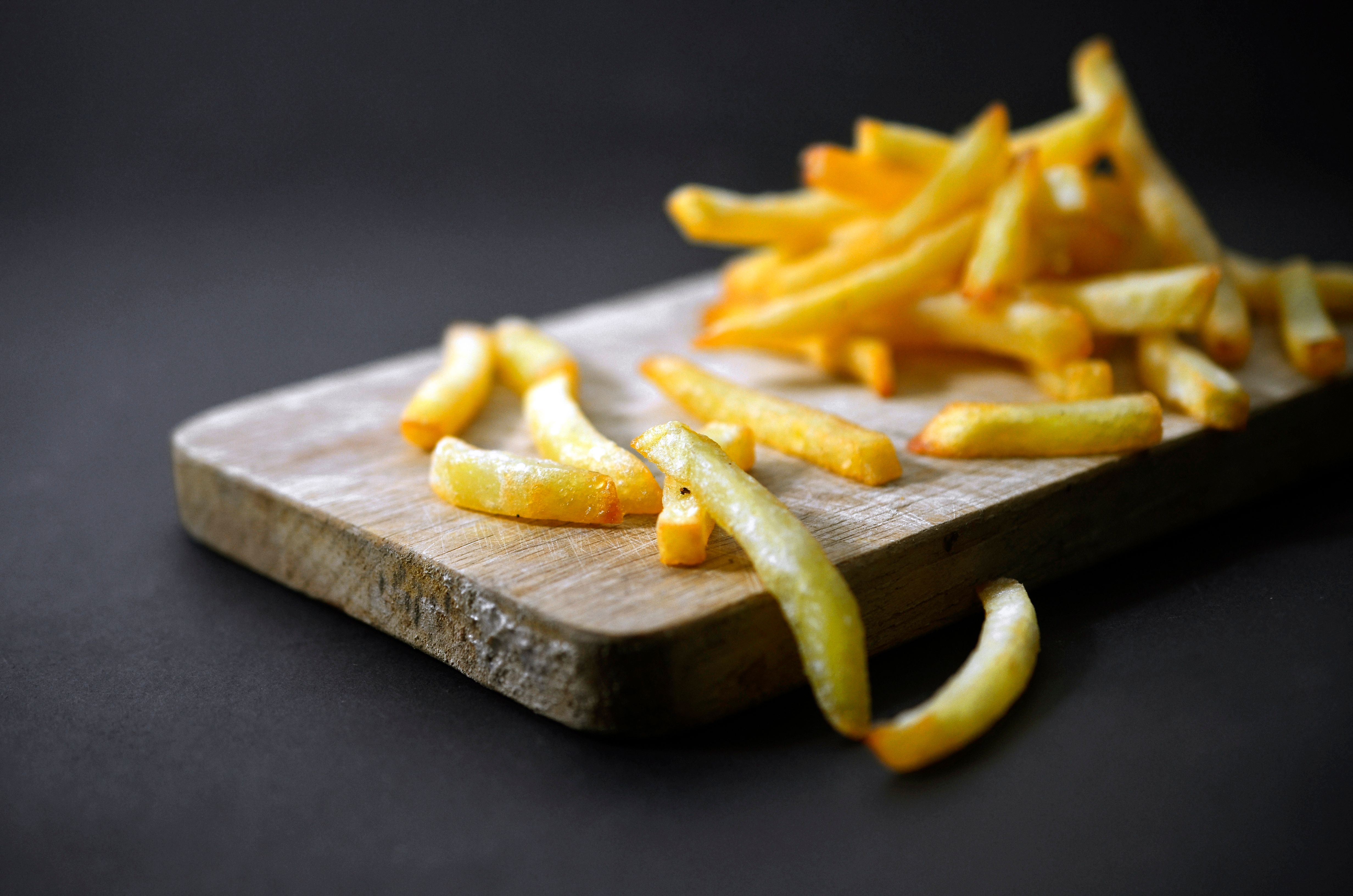 Fried Frech Fries Potato On Wooden Plate On Black Background