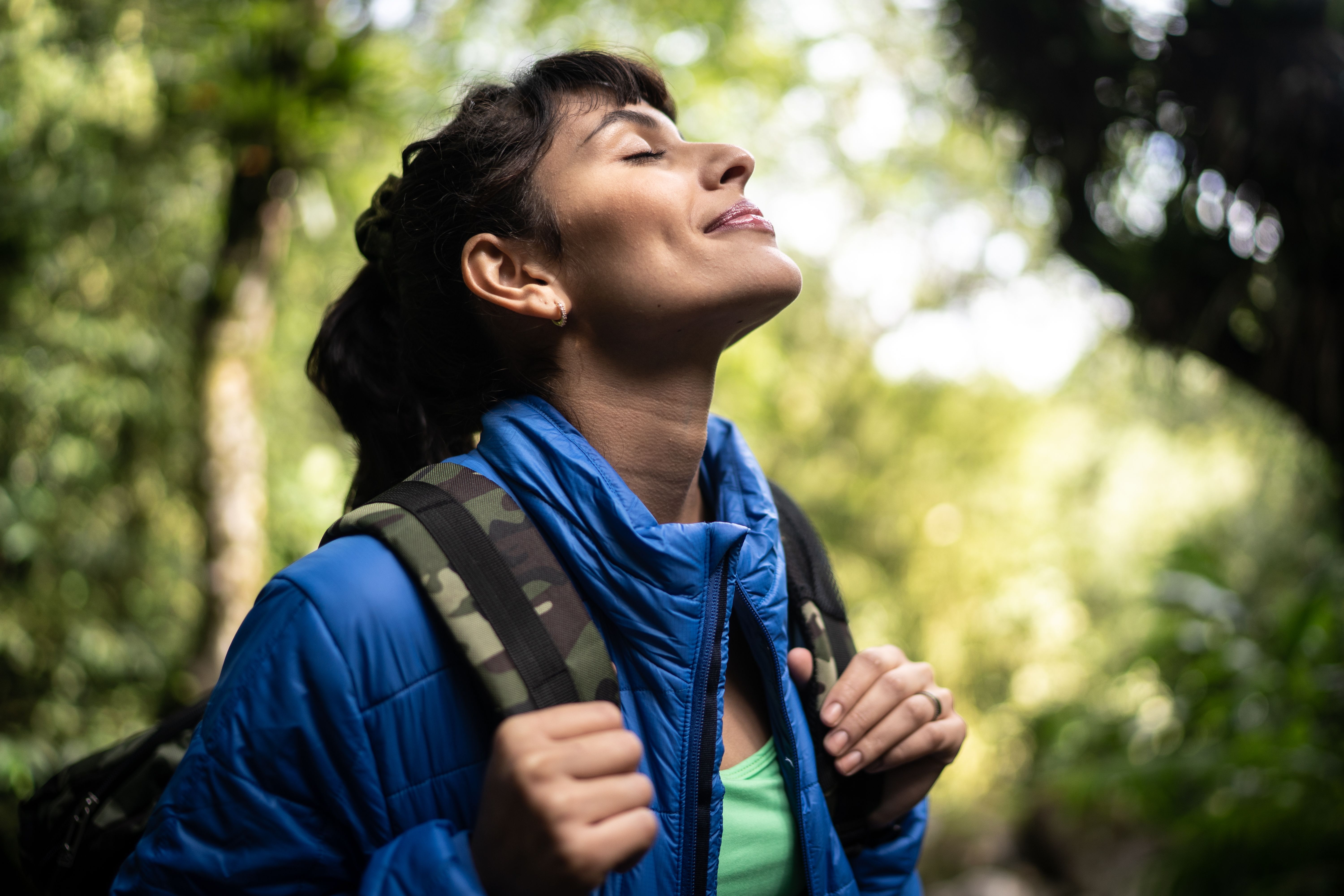 Young woman breathing pure air in a forest