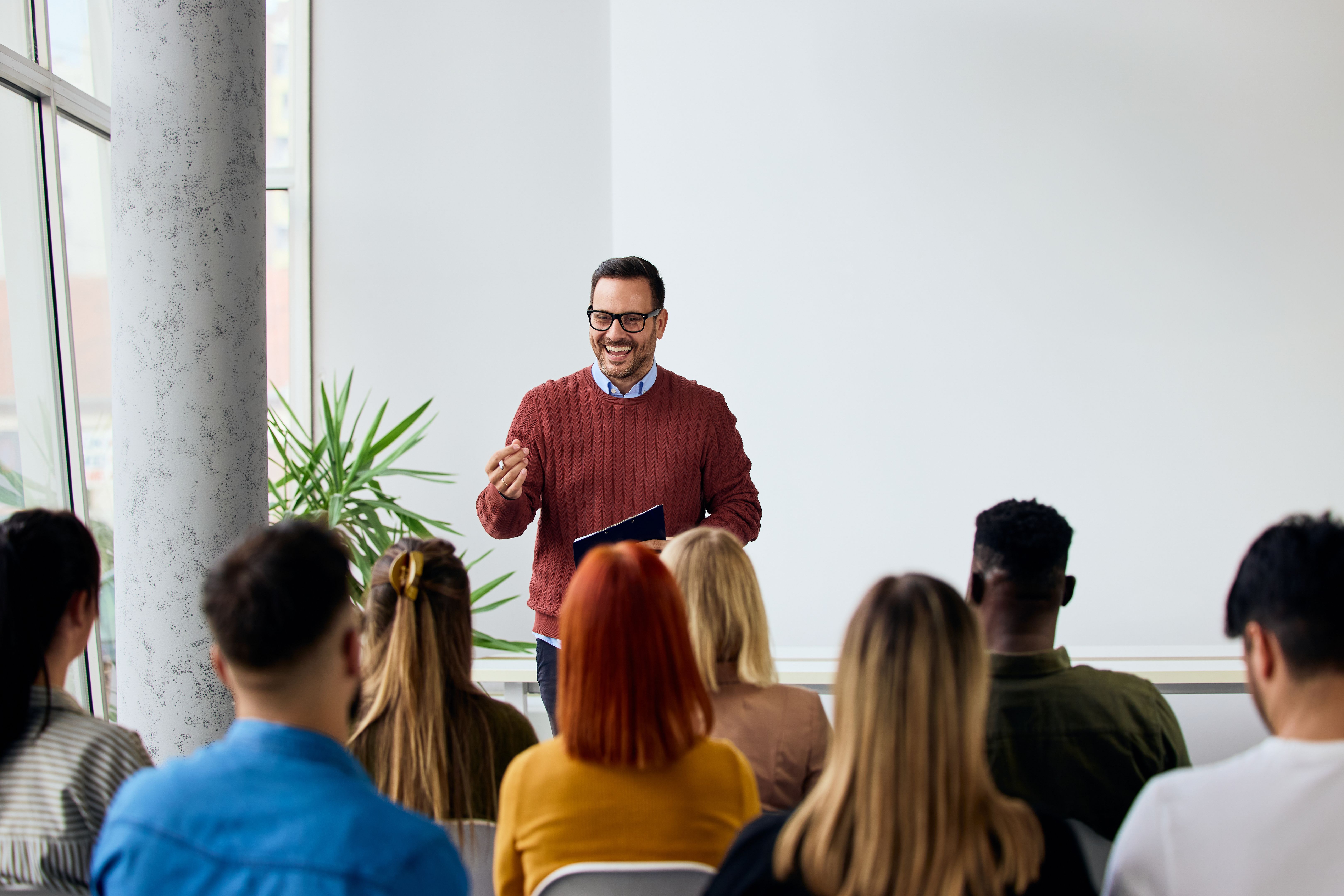 Conférencier professionnel animant une session de formation en entreprise pour des employés engagés dans un bureau moderne