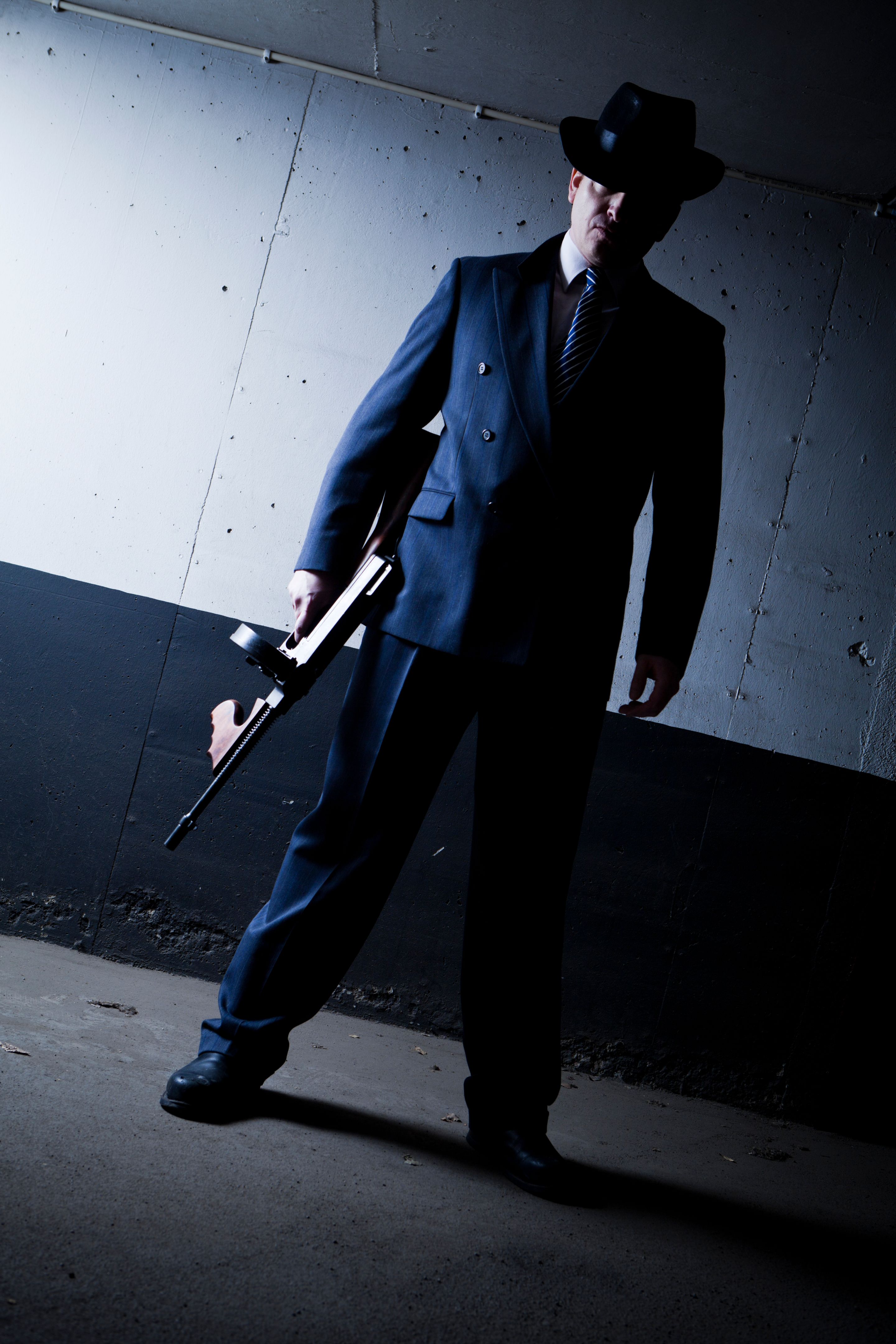 Old style gangster with tommy gun in dark setting
