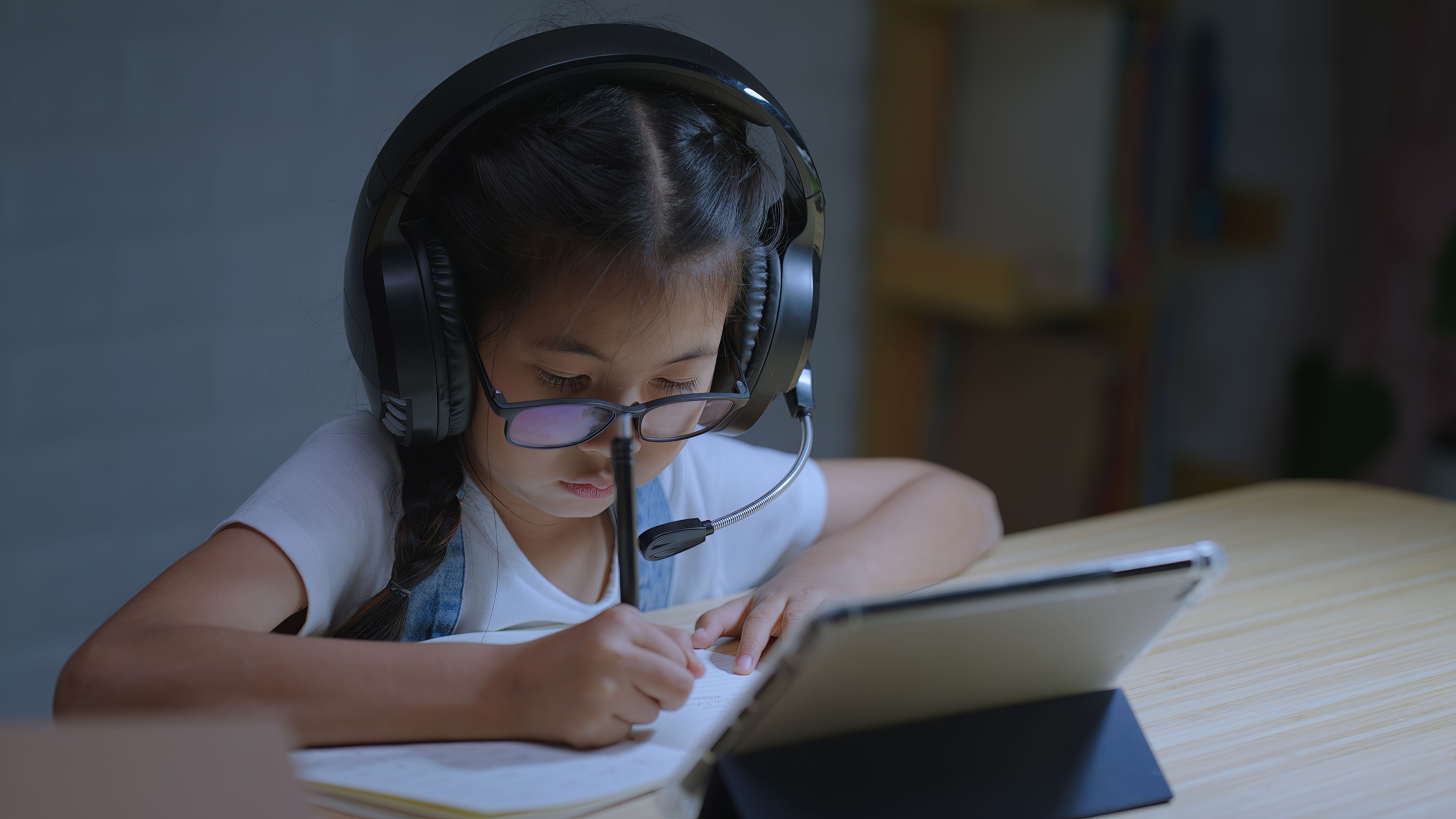 Young Girl Engaged in Online Learning with Headset at Night at Home
