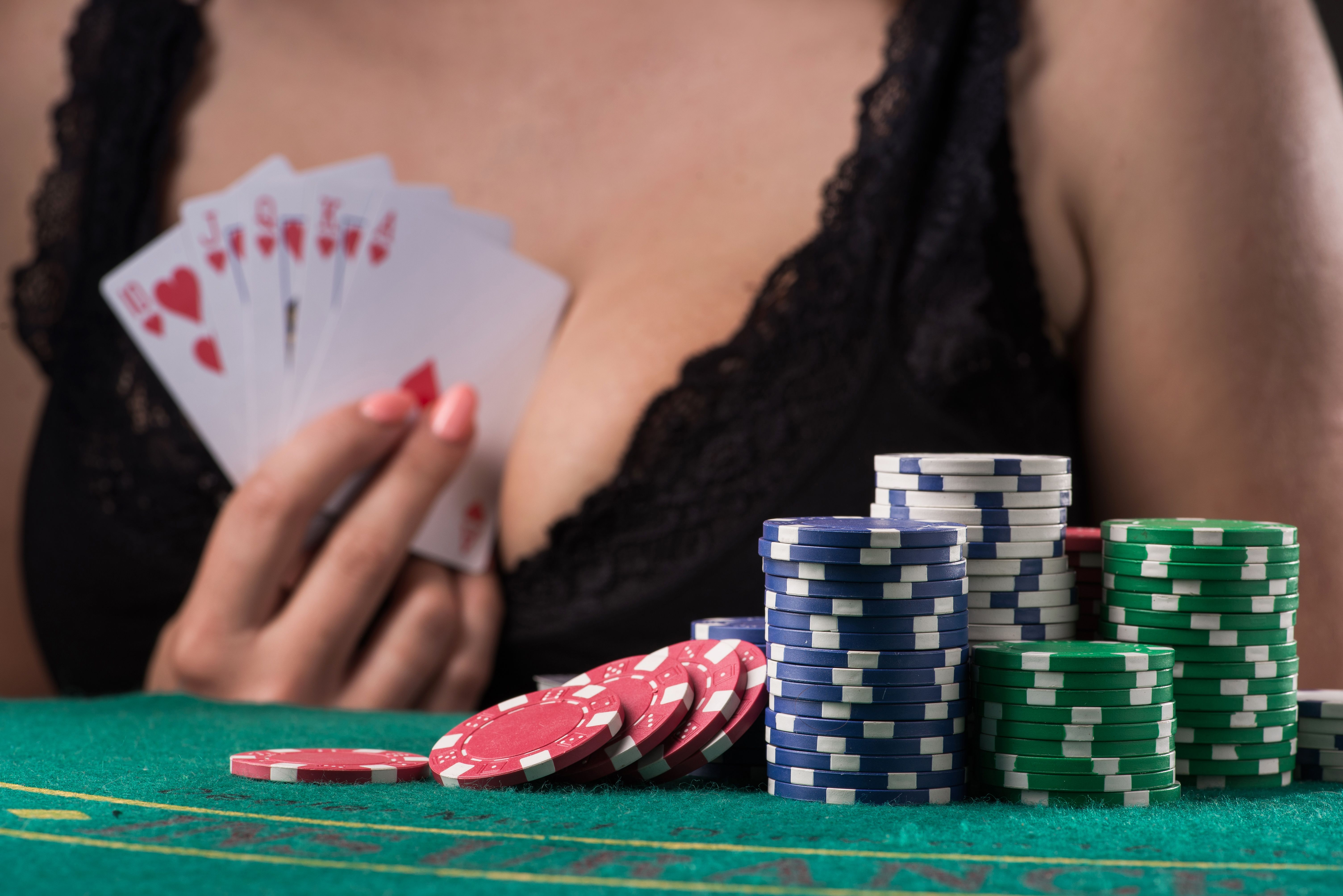 woman holding royal flush cards  on dark background