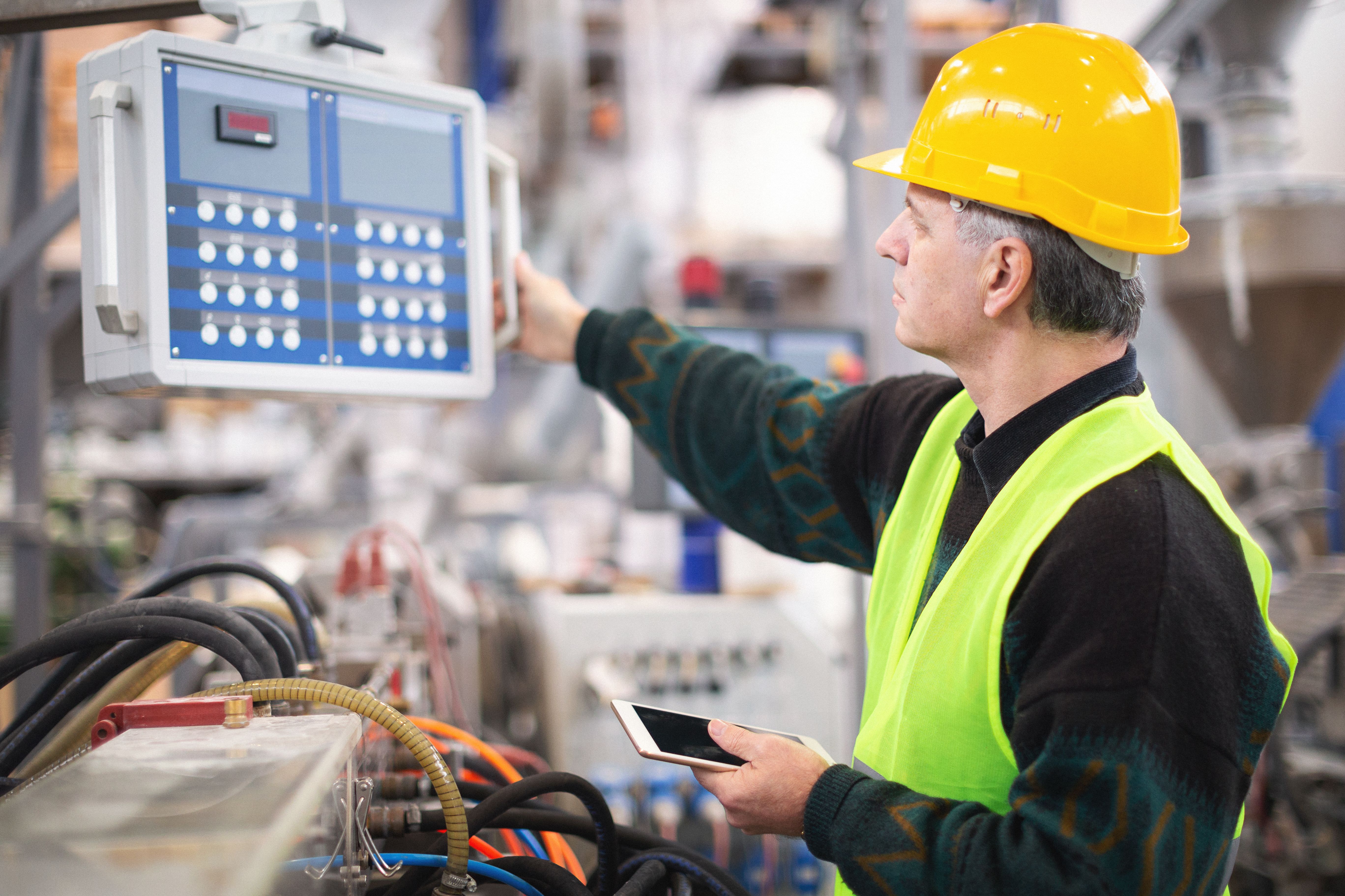 Senior worker in the factory operating machines