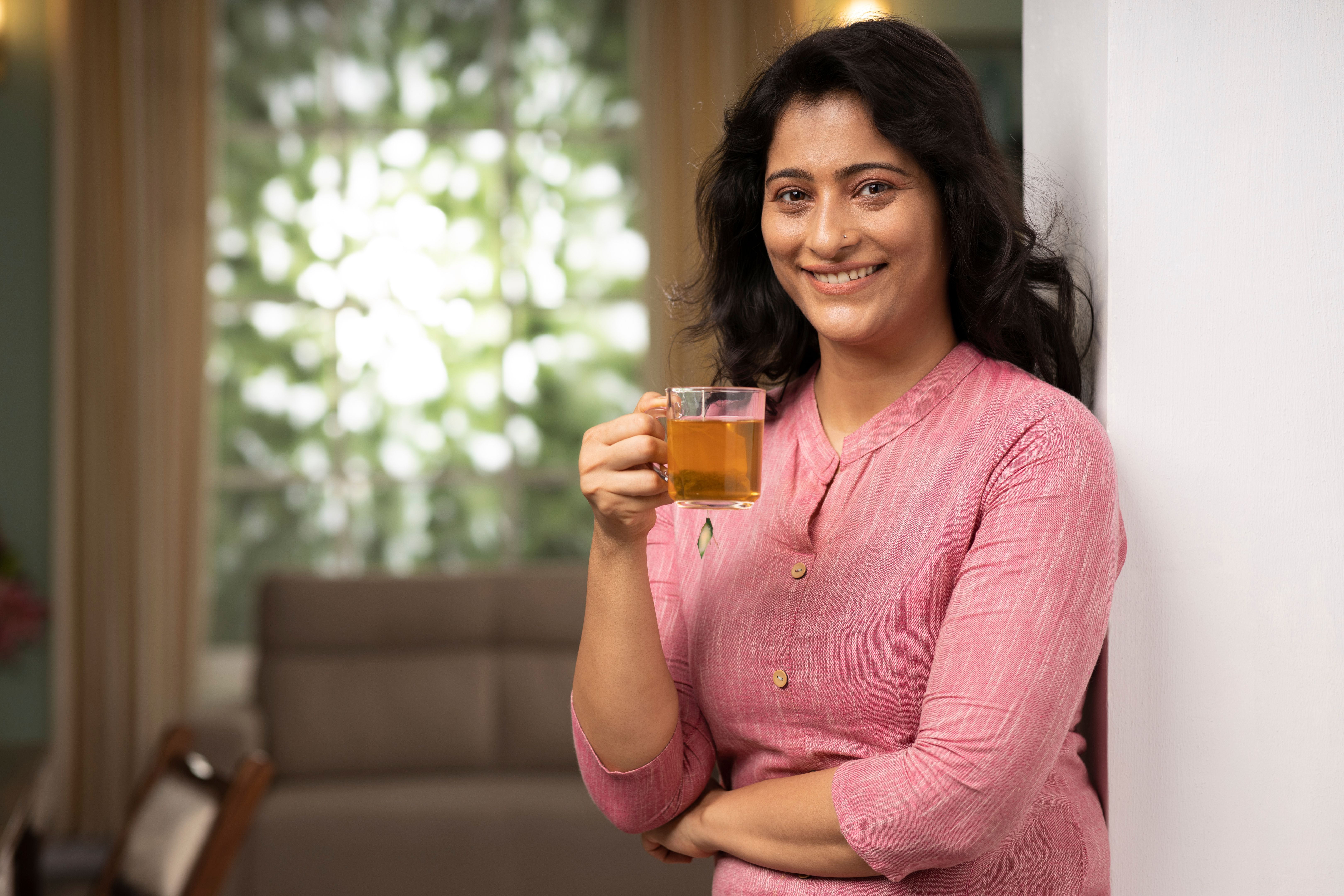 Young woman drinking cup of herbal tea at home stock photo Young woman drinking cup of herbal tea at home stock photo