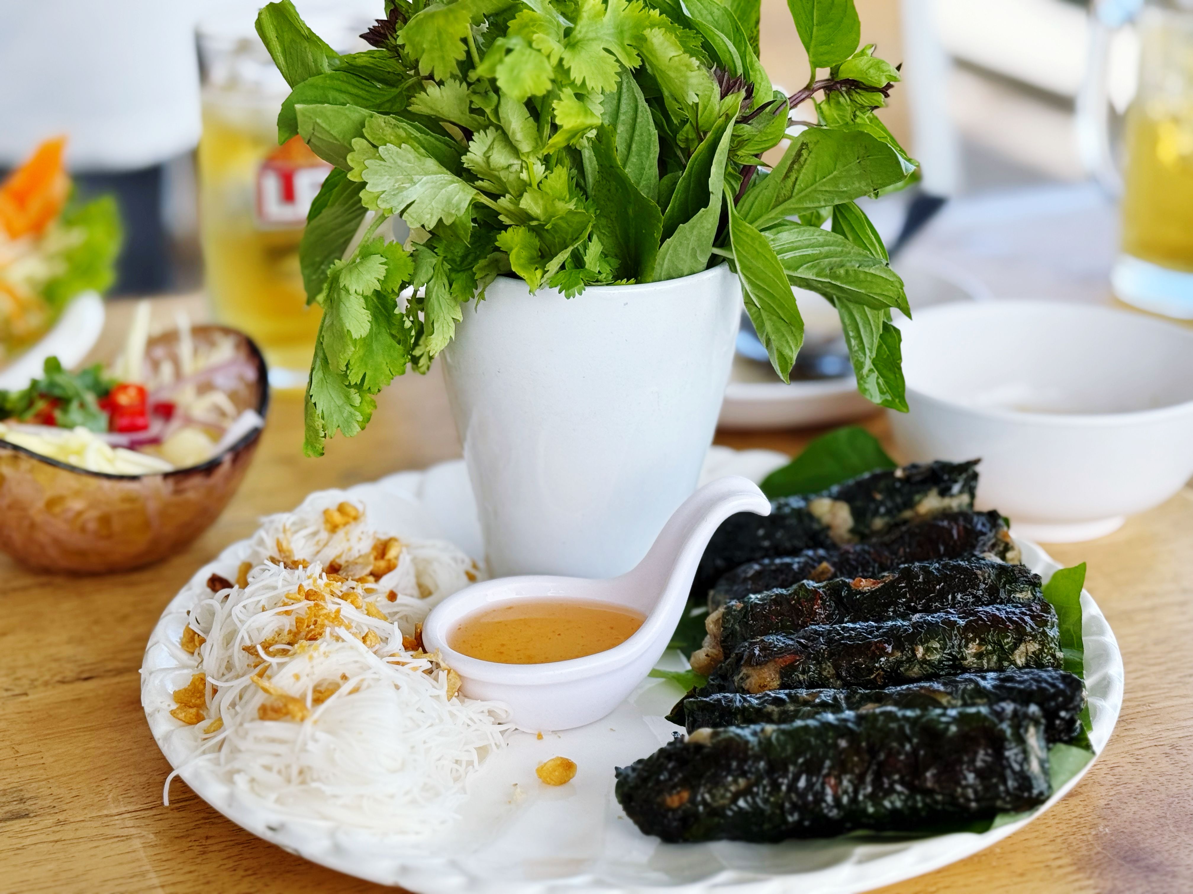Crispy fried dumplings with sauce and herbs on plate