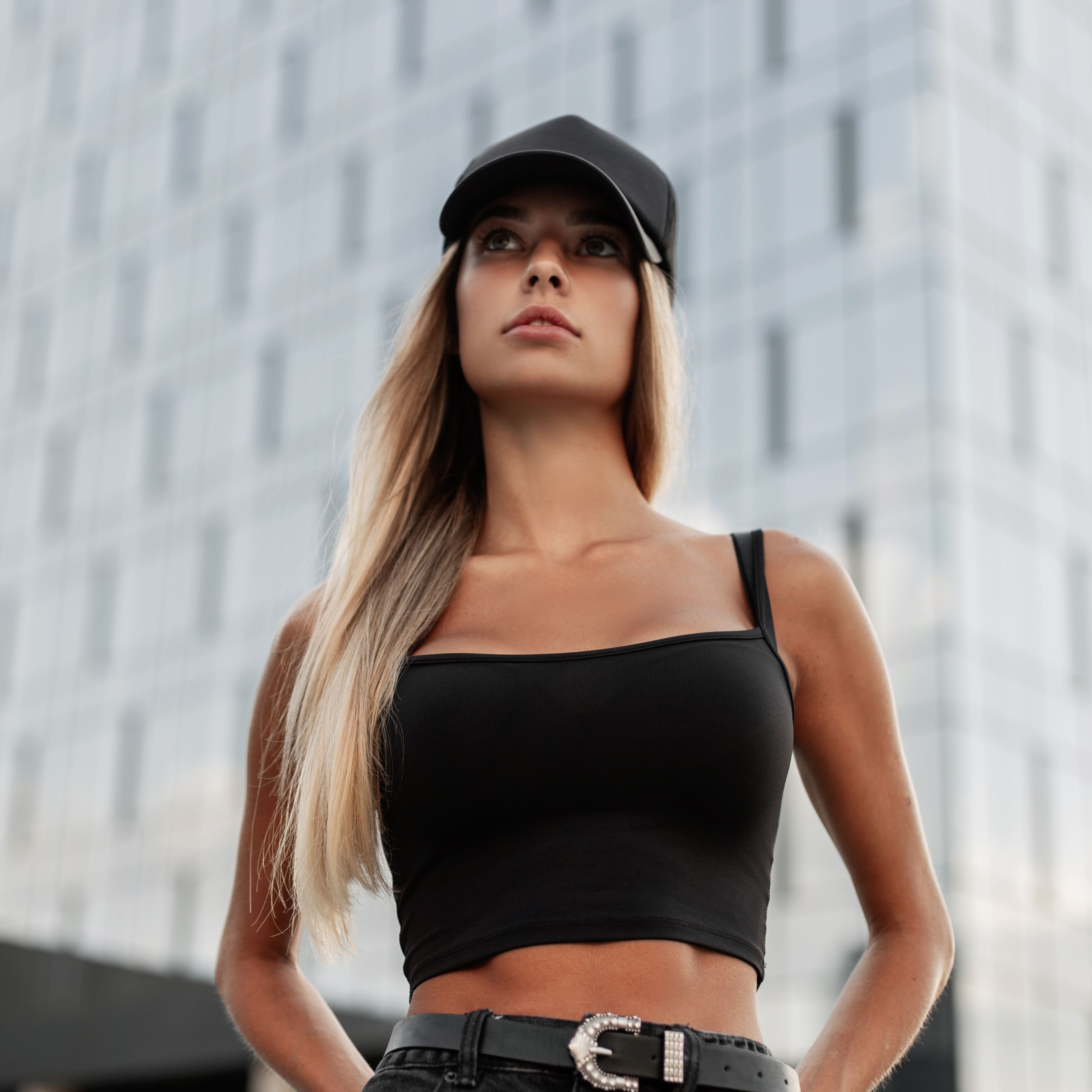 Stylish beautiful woman with a black fashionable cap with a mockup for design in a black t-shirt stands in the city Stylish beautiful woman with a black fashionable cap with a mockup for design in a black t-shirt stands in the city