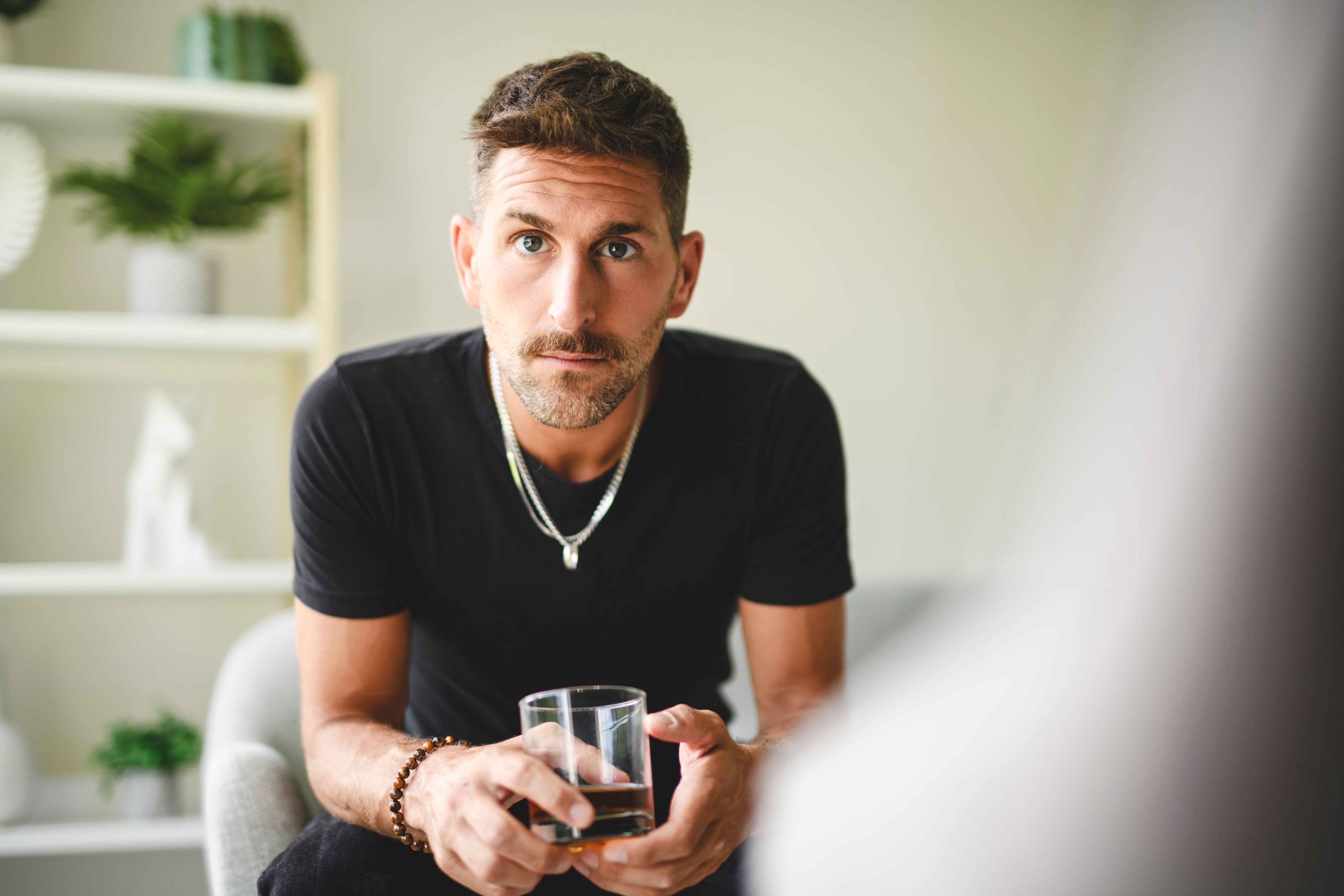 alone depressed male drink booze on sofa at home. Treatment of alcohol addiction, suffer abuse problem alcoholism.