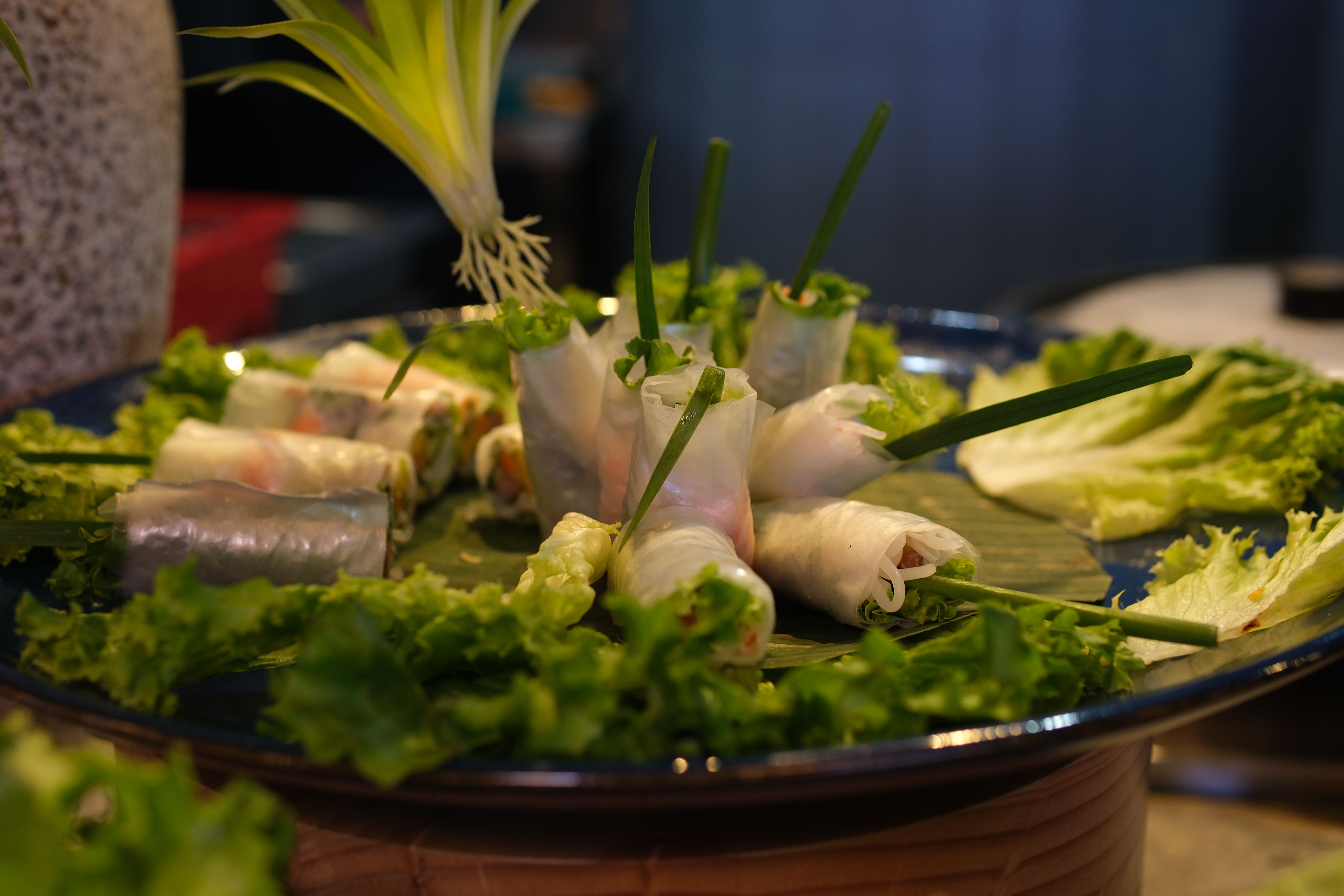 Spring rolls lettuce rice paper rolls Tourists prepare and eat spring roll with rice paper wrapper or banh trang at night streetfood market. Traditional Vietnamese nem dish, asian cuisine. Close up