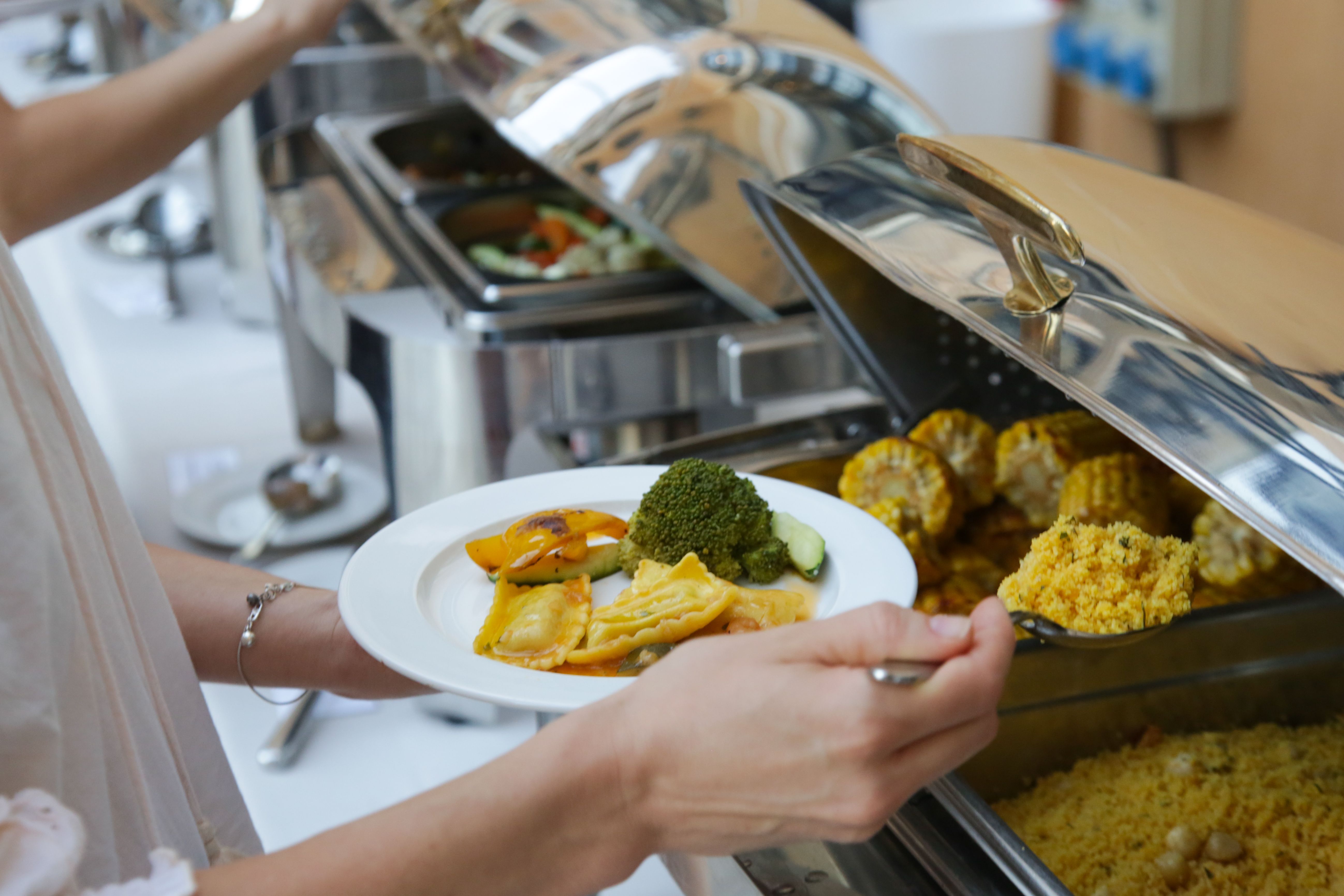 Woman taking food from a buffet line Woman taking food from a buffet line