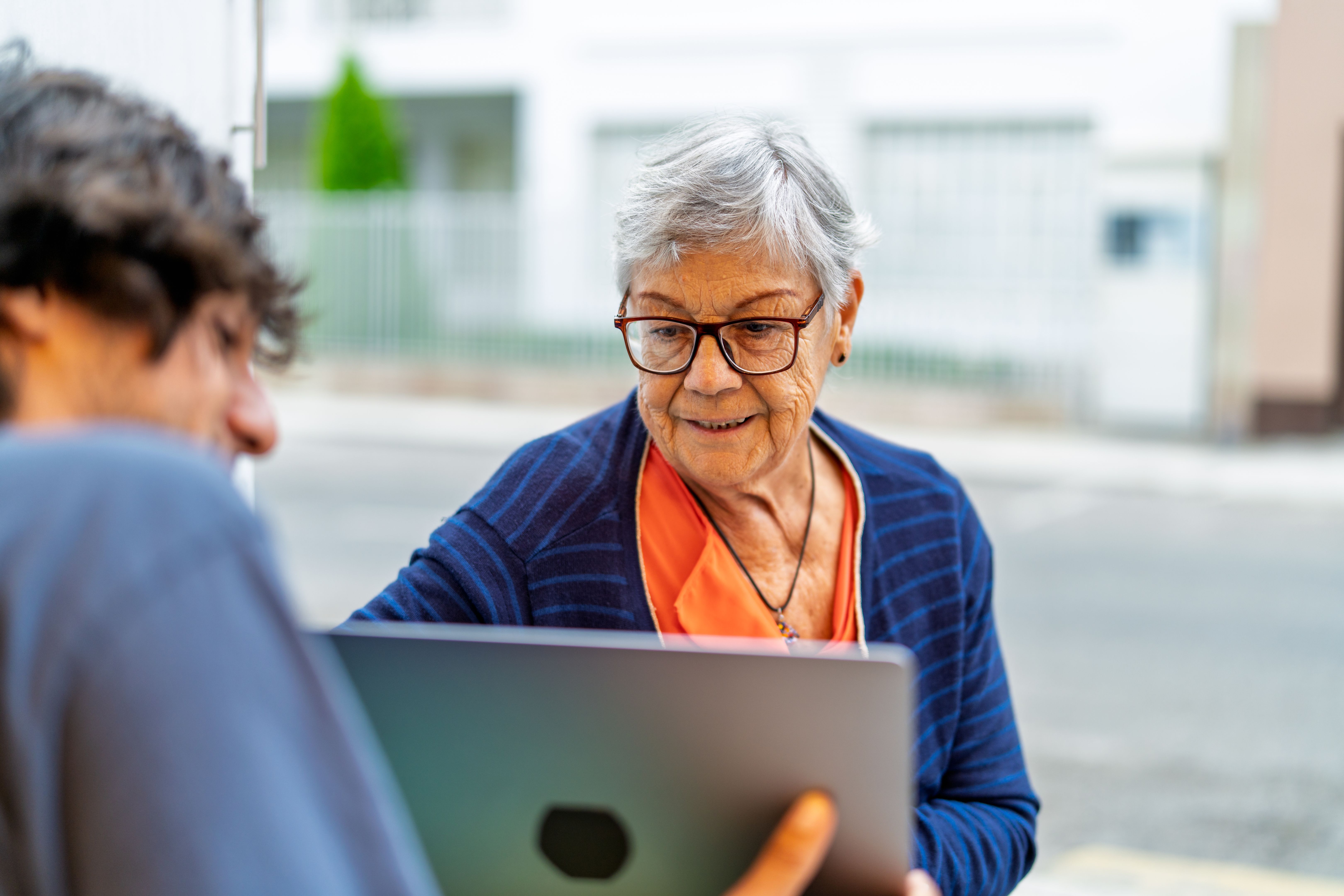 Young calgary adult engaging with senior woman on laptop