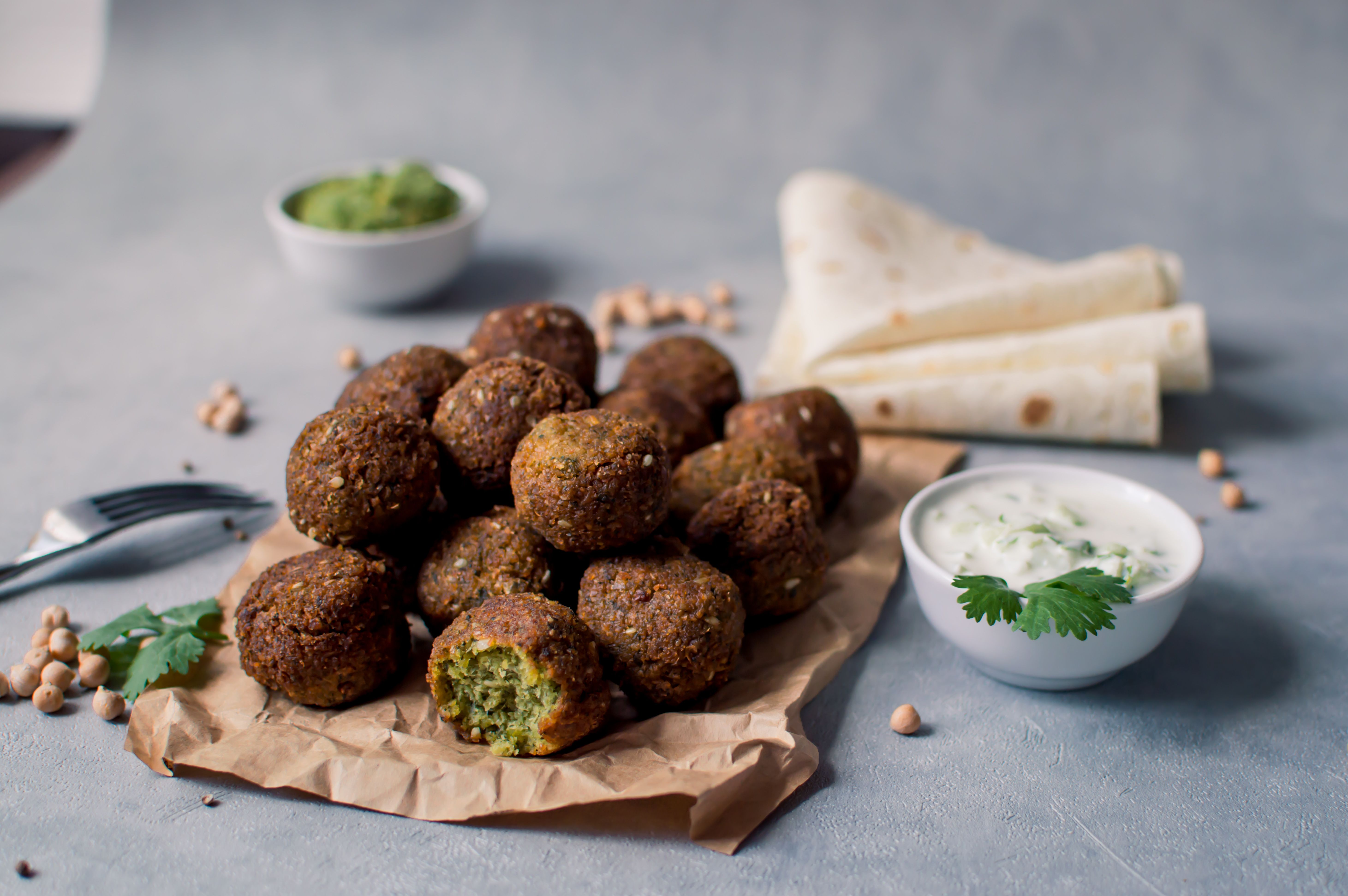 Fresh falafel balls on a black gray background with yoghurt sauce. Vegetarian food