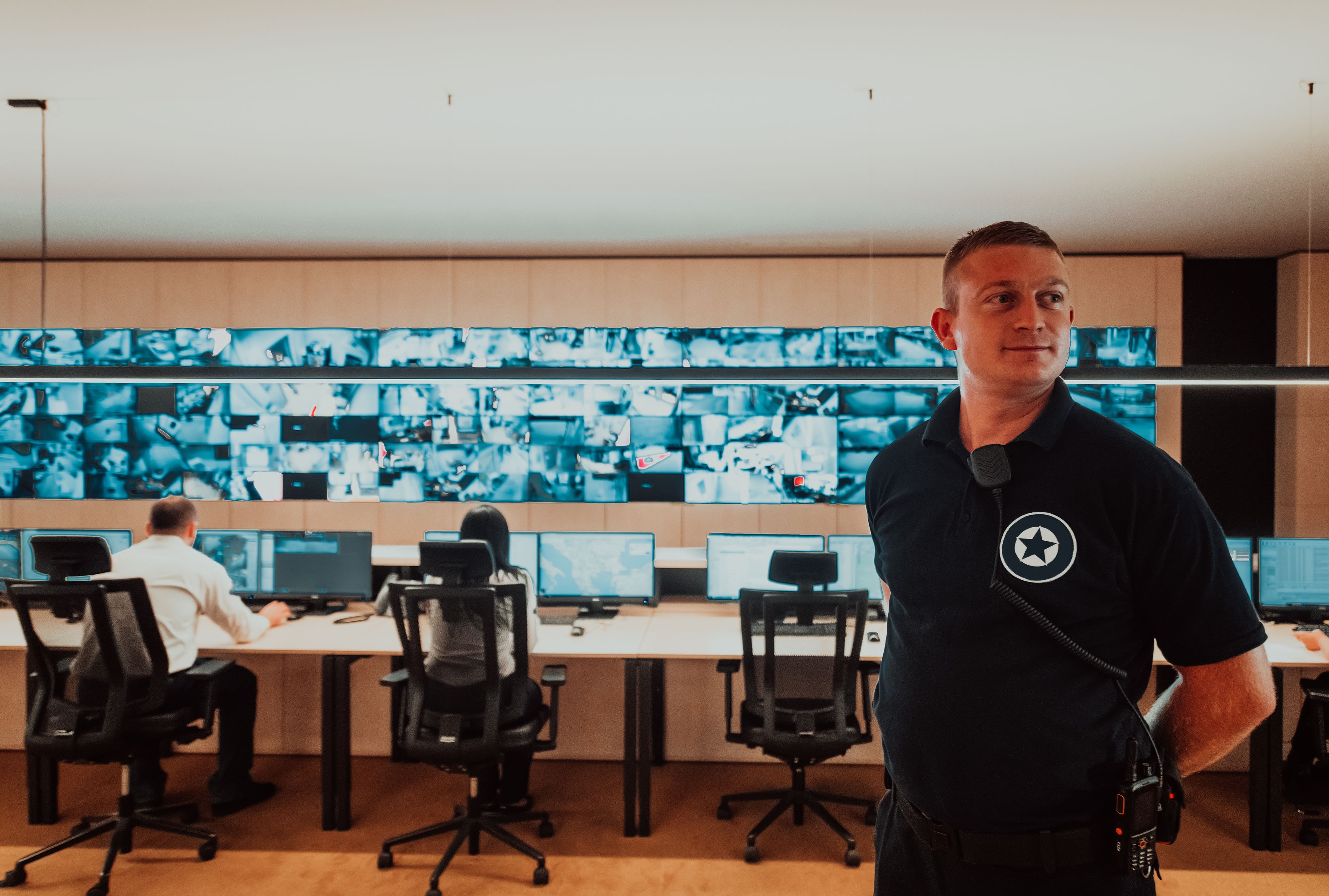 Male security operator working in a data system control room offices Technical Operator Working at workstation with multiple displays, security guard working on multiple monitors Male computer opera