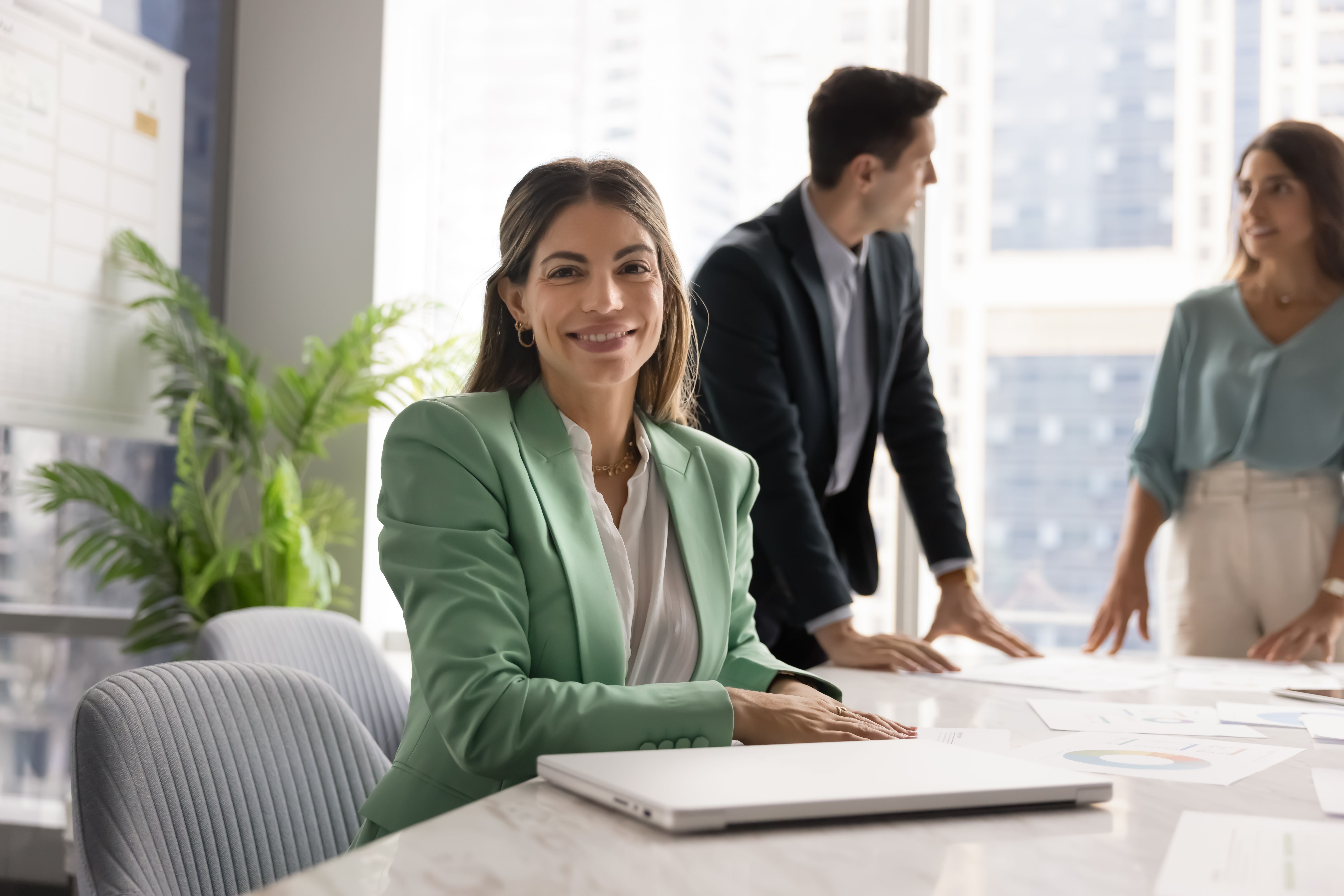 Portrait of businesswoman smiling at camera, sitting at conference table